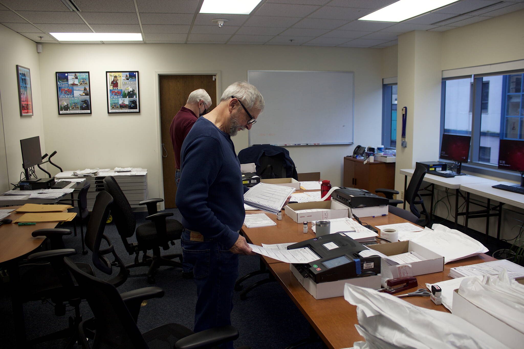 Steve Lewis, foreground, and Stephen Sorensen from the Alaska State Review Board scan ballots from precincts where they were hand counted at the Division of Elections office Tuesday. The hand counts were for first-choice votes only, while the scans will be used for ranked choice tallies for any races where a candidate does not have a first-choice majority. (Mark Sabbatini / Juneau Empire)