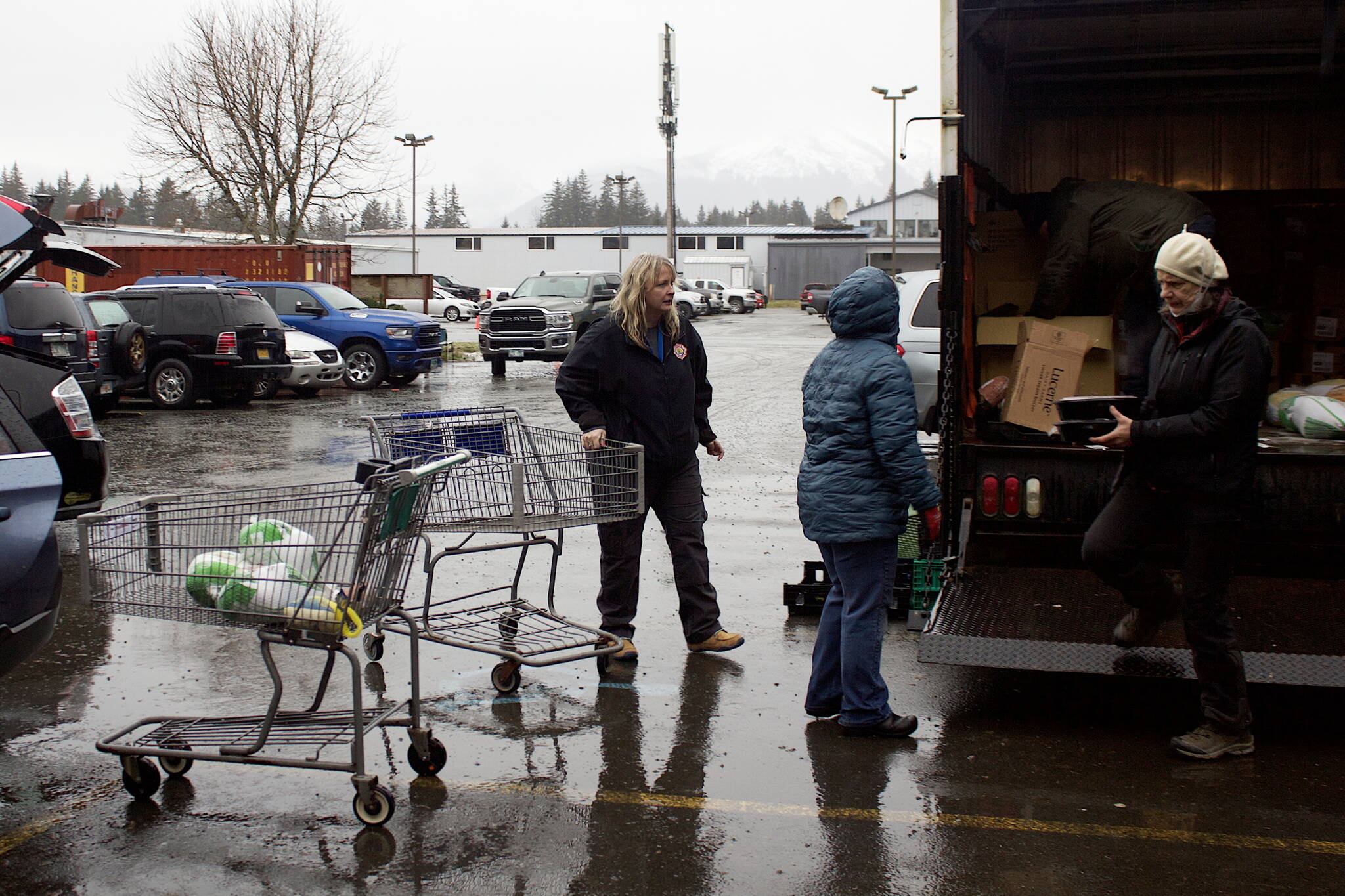 Volunteers load Thanksgiving grocery baskets into vehicles for Saturday morning delivery in the St. Vincent de Paul parking lot.  (Mark Sabbatini / Juneau Empire)