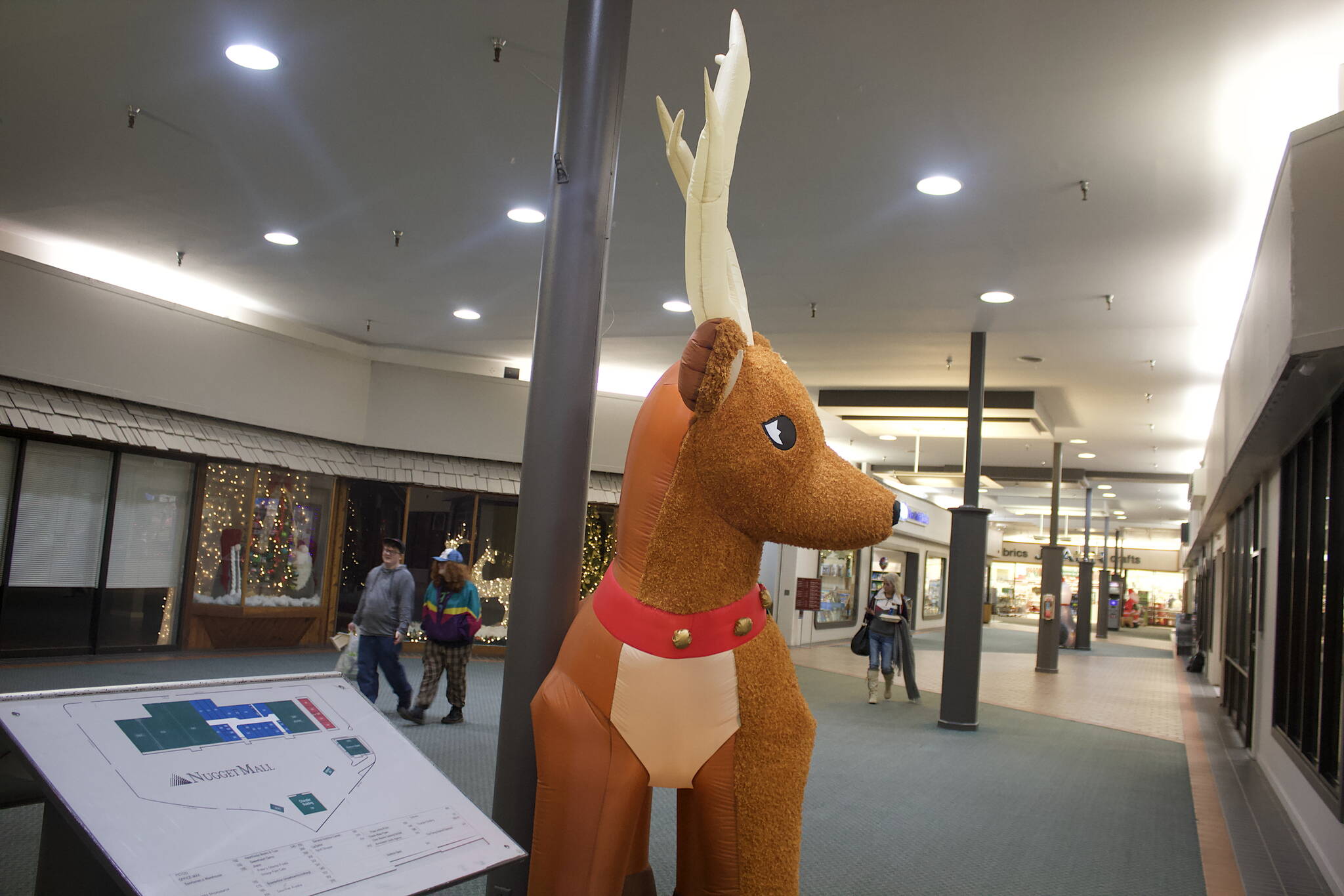 A larger-than-life reindeer awaits holiday shoppers near an entrance at Nugget Mall on Wednesday, where there were no obvious “Black Friday” signs or banners on display, but merchants are nonetheless readying sales prices in the hopes of luring an increased flow of traffic. (Mark Sabbatini / Juneau Empire)