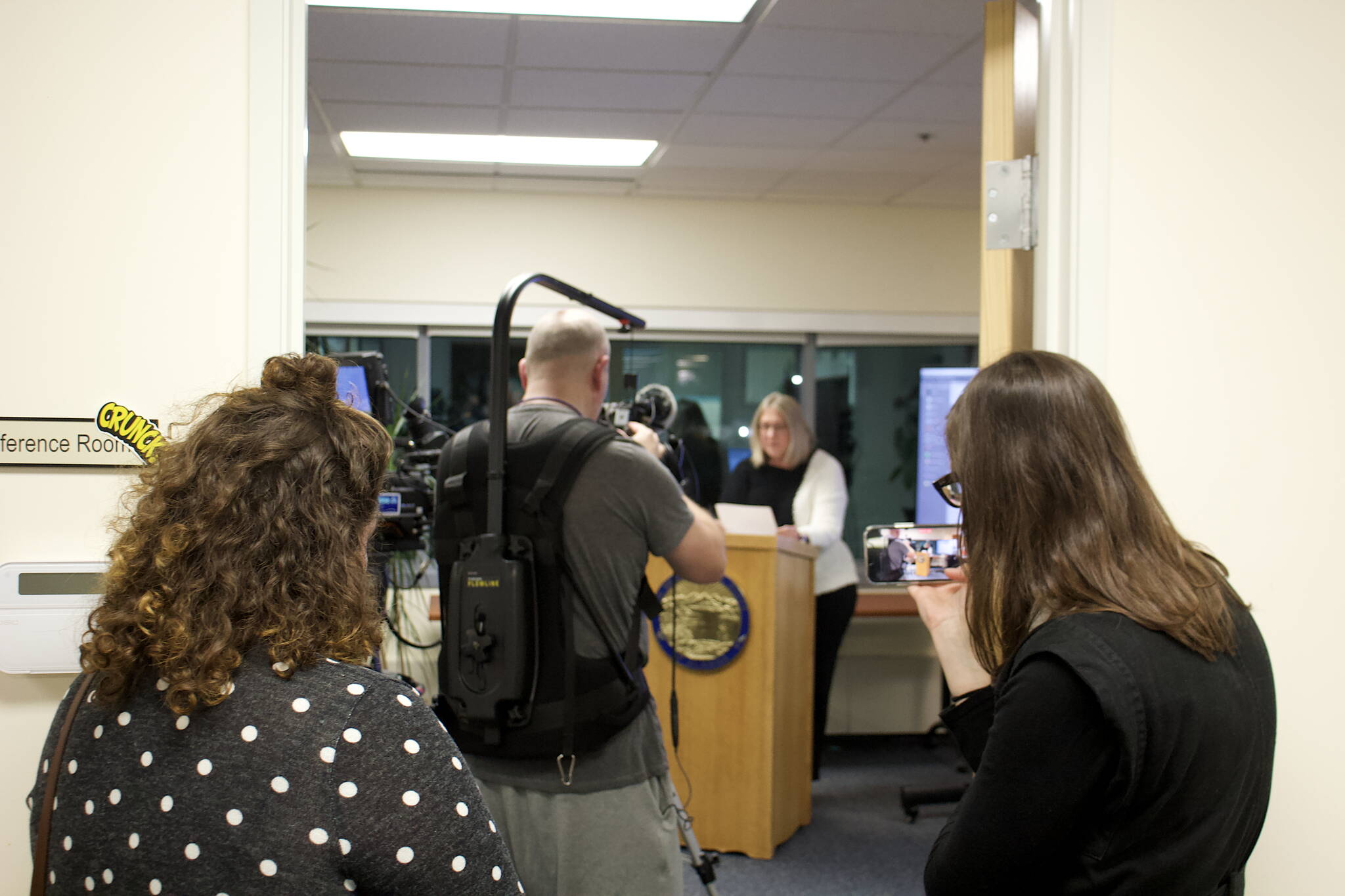 A few members of the media and observers watch the ranked choice tally being filmed by public broadcaster KTOO in the Alaska Division of Elections director’s office in Juneau on Wednesday afternoon. While the state’s first ranked choice general election got widespread national attention, including from skeptics questioning the integrity of the process, no such doubters were at the count and elections officials said harassment by observers experienced by employees in other states has not occurred here. (Mark Sabbatini / Juneau Empire)