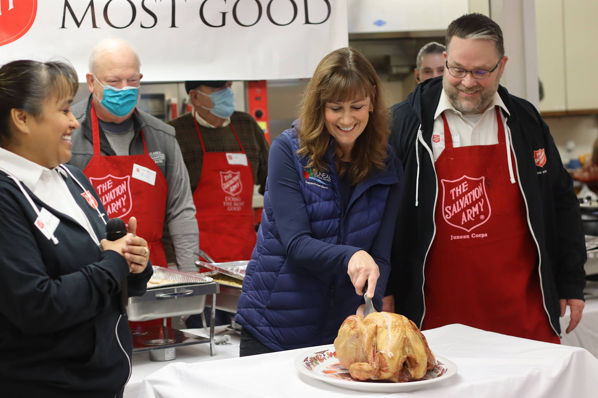 Juneau School District Superintendent Bridget Weiss performs the ceremonial first carving of a turkey at The Salvation Army’s annual Thanksgiving Day meal at the Juneau Yacht Club. Weiss, who is retiring next year after a 40-year career in education, said she is thankful her family is in good health and for the people she’s interacted with during her time at local schools. (Mark Sabbatini)