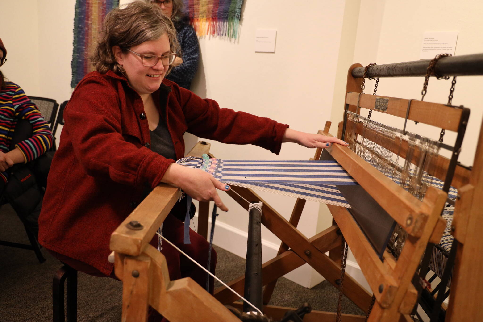 Mary McEwen gives a demonstration of her vintage loom during her Artist Talk Saturday morning about her exhibition, “Hit & Miss: Adventures in Textile Reuse,” at the Juneau-Douglas City Museum. (Clarise Larson / Juneau Empire)
Mary McEwen gives a demonstration of her vintage loom during her Artist Talk Saturday morning about her exhibition, “Hit & Miss: Adventures in Textile Reuse,” at the Juneau-Douglas City Museum. (Clarise Larson / Juneau Empire)