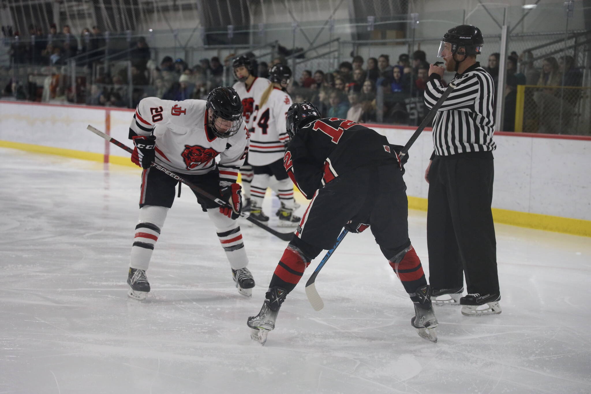Senior and team assistant captain Brandon Campbell faces off during a home game between Juneau-Douglas High School: Yadaa.at Kalé Crimson Bears Varsity hockey team and the Kenai Central Kardinals at the Treadwell Arena Saturday afternoon. (Clarise Larson / Juneau Empire)