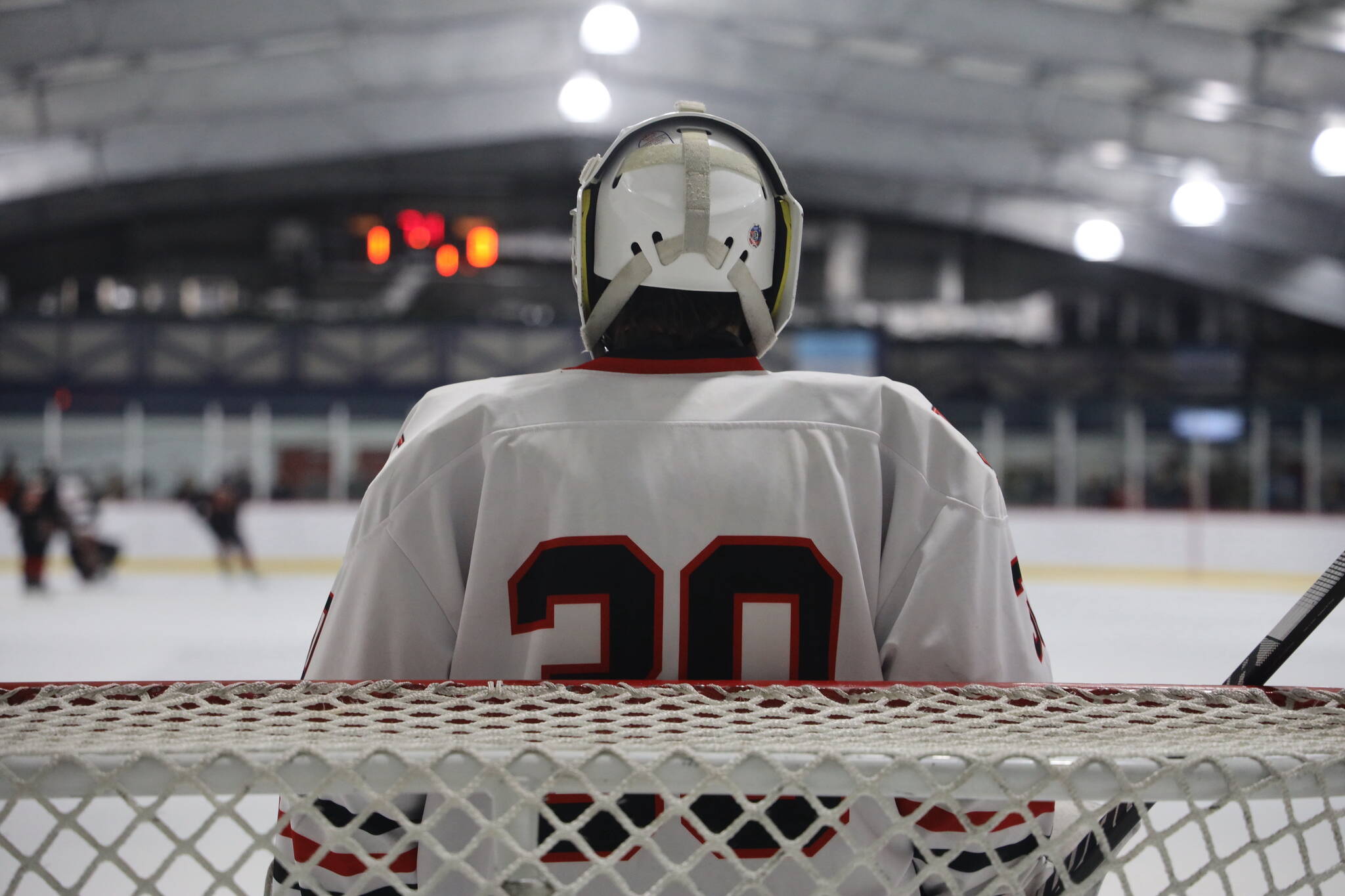 Junior Mason Sooter tends the net as the puck is in the opposite zone during a home game between Juneau-Douglas High School: Yadaa.at Kalé Crimson Bears Varsity hockey team and the Kenai Central Kardinals at the Treadwell Arena Saturday afternoon. (Clarise Larson / Juneau Empire)