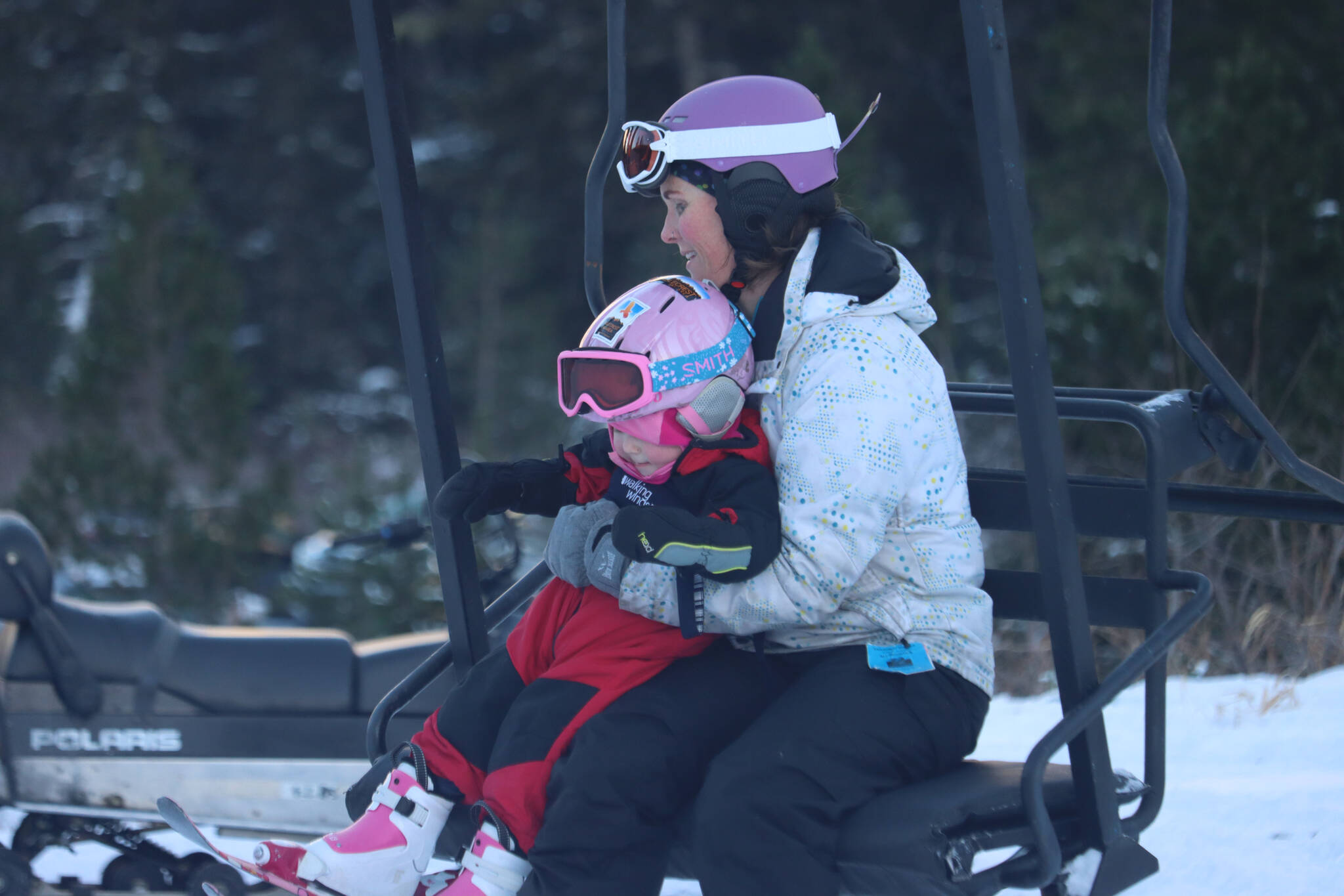 Jada Kahl takes her daughter Azalea Kahl up the Porcupine Lift at Eaglecrest Ski Area on opening day, Saturday. (Jonson Kuhn / Juneau Empire)