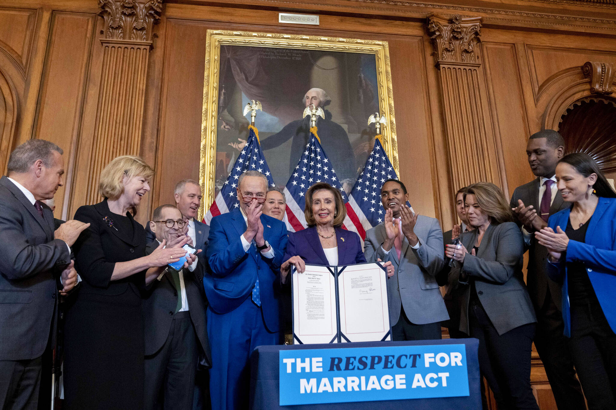 House Speaker Nancy Pelosi of Calif., accompanied by Senate Majority Leader Sen. Chuck Schumer of N.Y., center left, and other members of congress, signs the H.R. 8404, the Respect For Marriage Act, on Capitol Hill in Washington, Thursday, Dec. 8, 2022. (AP Photo / Andrew Harnik)