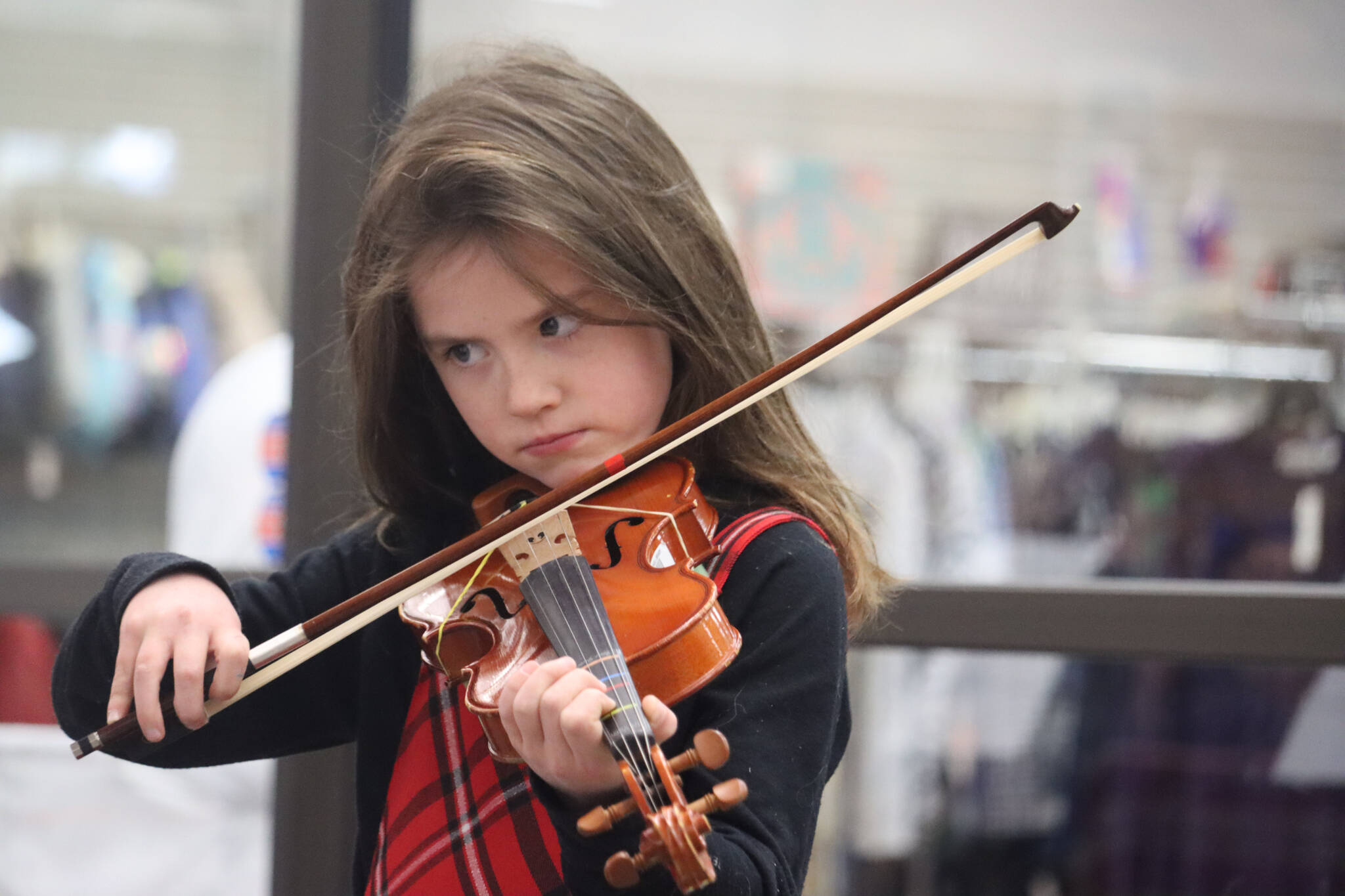 B. Thomas of the beginner level violins with Juneau Alaska Music Matters plays for a full crowd at the Mendenhall Mall during the annual Juneau Holiday Village on Saturday. (Jonson Kuhn / Juneau Empire)