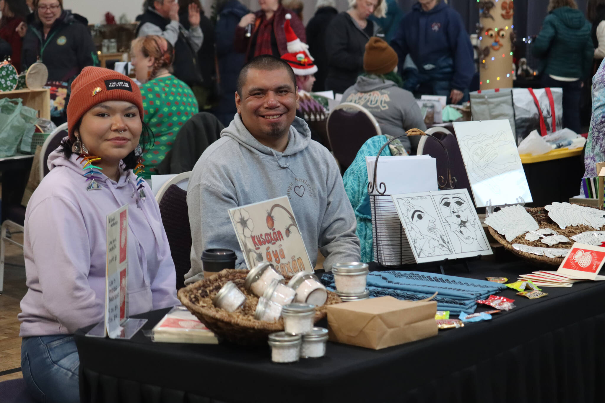 Corinne and Lyle James celebrate their new business venture, Tlingit Aesthetics, selling stickers, prints, cards and apparel at the annual Stocking Stuffer Showcase on Saturday, Dec. 10. (Jonson Kuhn / Juneau Empire)