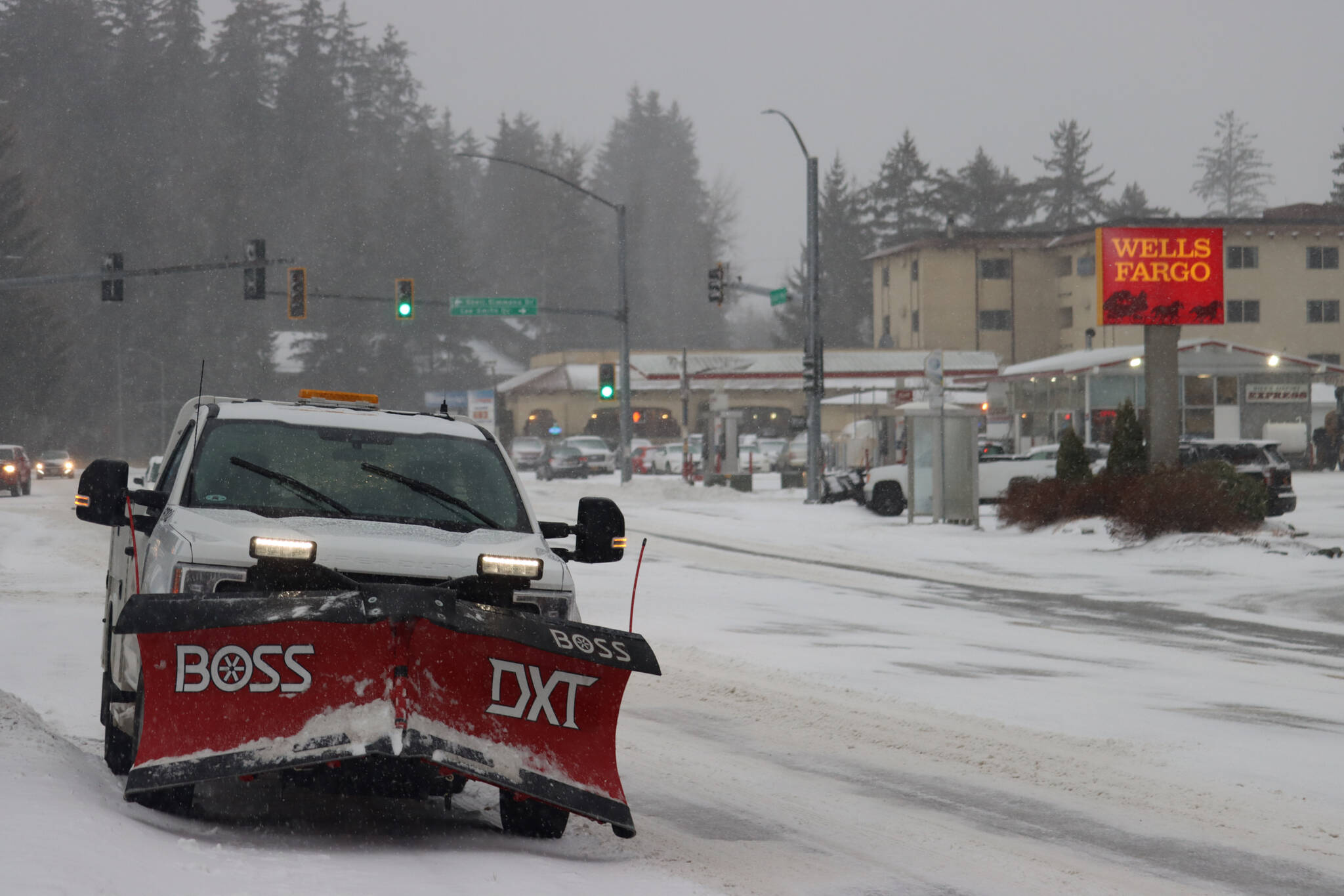 A snow plow pulls off of Glacier Highway to clear the sidewalks near a bus stop during heavy snow fall on Monday morning. (Jonson Kuhn / Juneau Empire)