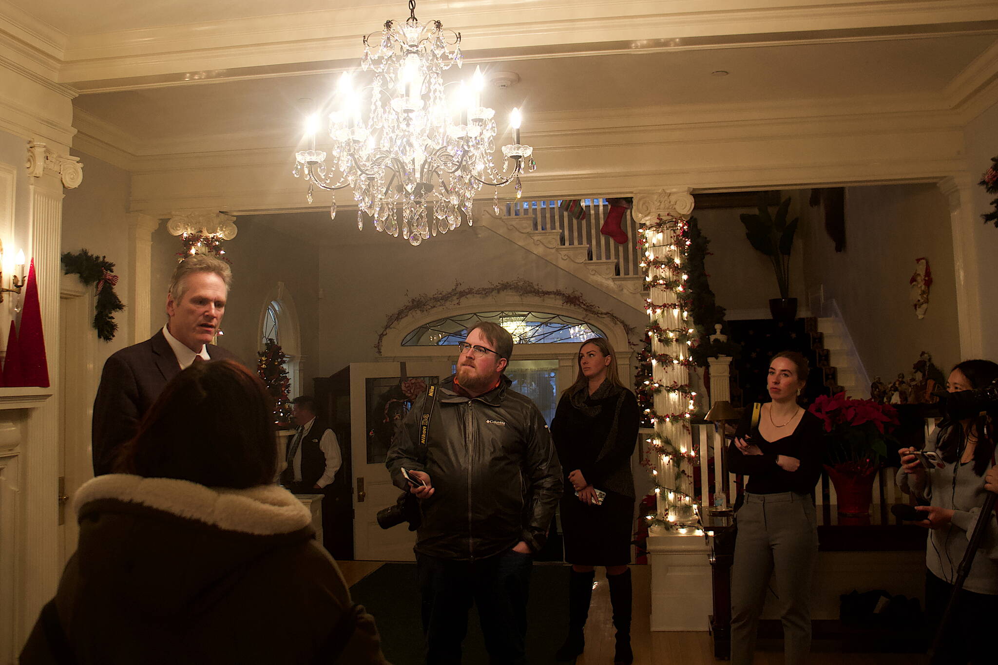 Gov. Mike Dunleavy answers media questions about his proposed budget for next year and the upcoming legislative session shortly before the annual holiday open house at the governor’s mansion on Tuesday. (Mark Sabbatini / Juneau Empire)