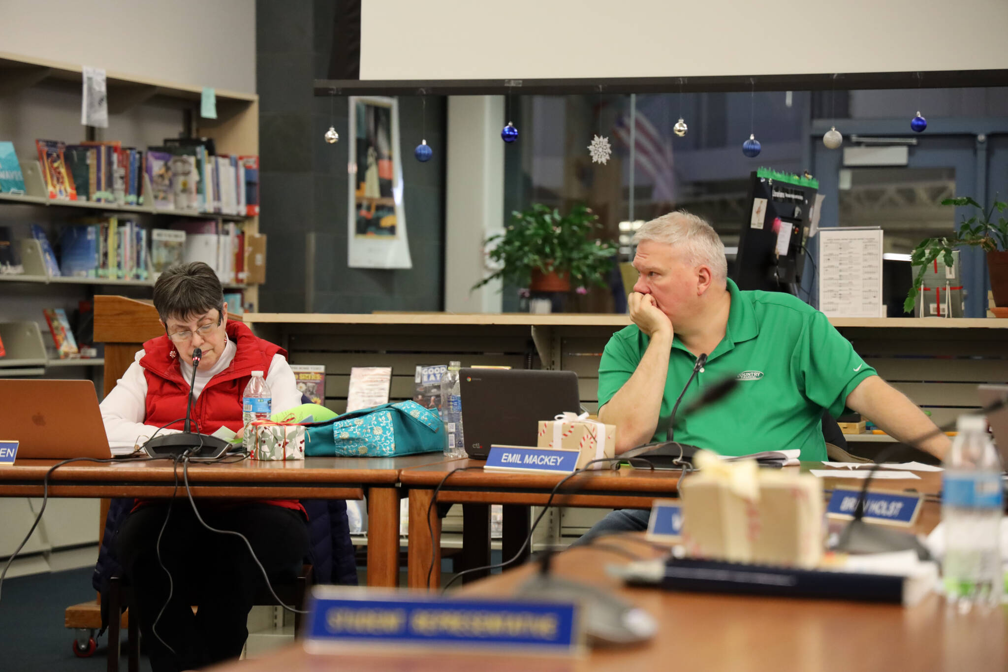 Juneau School Board President Deedie Sorensen and Vice President Emil Mackey discuss ‘milk’ incident investigation bid and extending food vendor’s contract with board members Tuesday evening. (Clarise Larson / Juneau Empire)