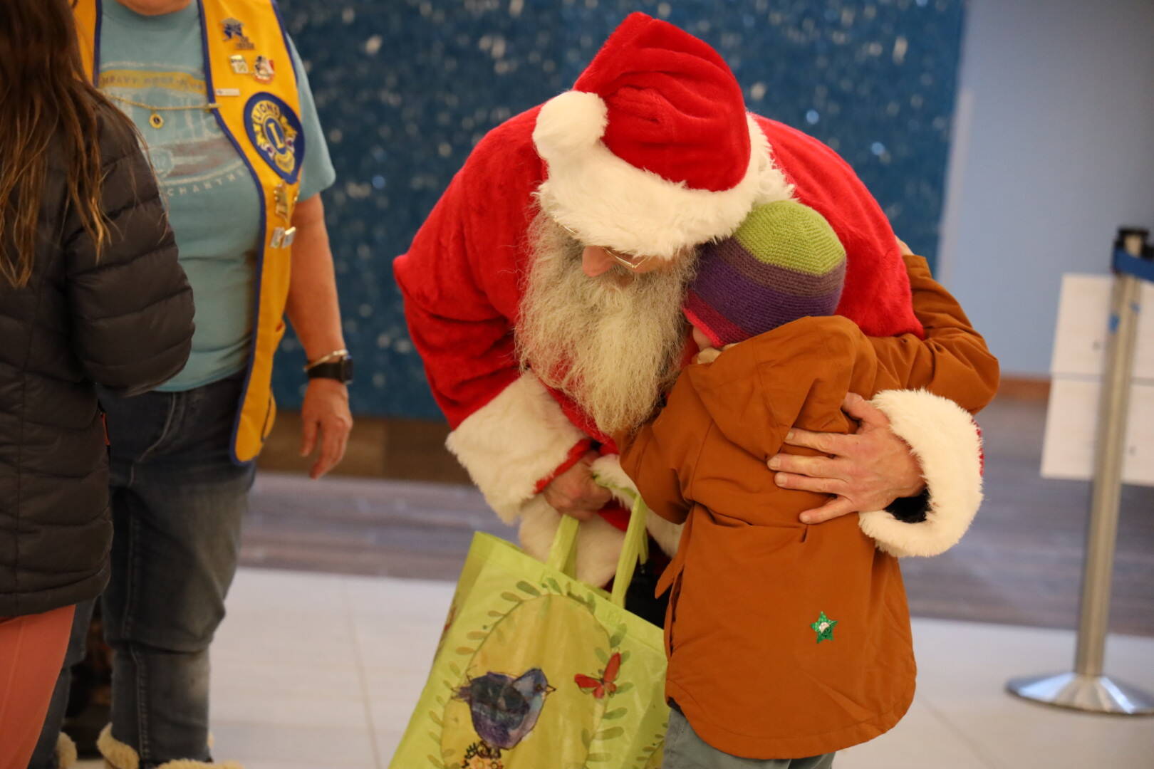 Clarise Larson / Juneau Empire 
Santa hugs Malachi Husemann,5, during Christmas Light Flights at Juneau International Airport.