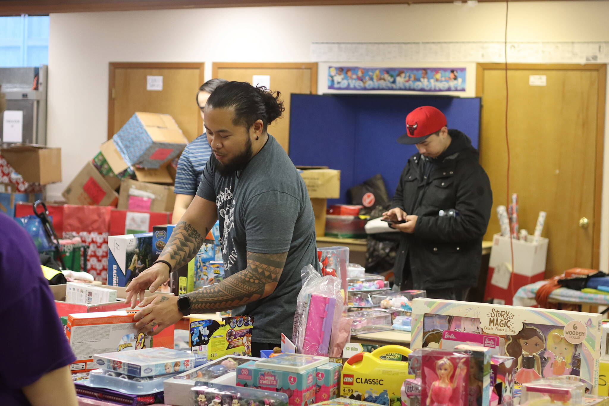 A volunteer selects donated toys for a recipient during The Salvation Army’s food and gift giveaway Saturday at its church and administrative office downtown. St. Vincent de Paul in Juneau is hosting its Adopt-A-Family gift giveaway this week, but had to stop accepting wish lists from families early due to higher-than-usual demand, according to Director Dave Ringle. People interested in helping a family can contact the organization by Thursday, (Mark Sabbatini / Juneau Empire)