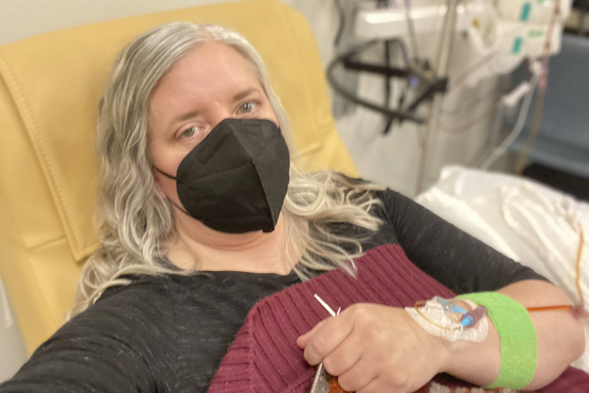 This photo provided by Amy Watson of Portland, Ore., shows her during an iron infusion in December 2022. Watson, approaching 50, says she has “never had any kind of recovery” from COVID-19. She has had severe migraines, plus digestive, nerve and foot problems. Recently she developed severe anemia. (Amy Watson)