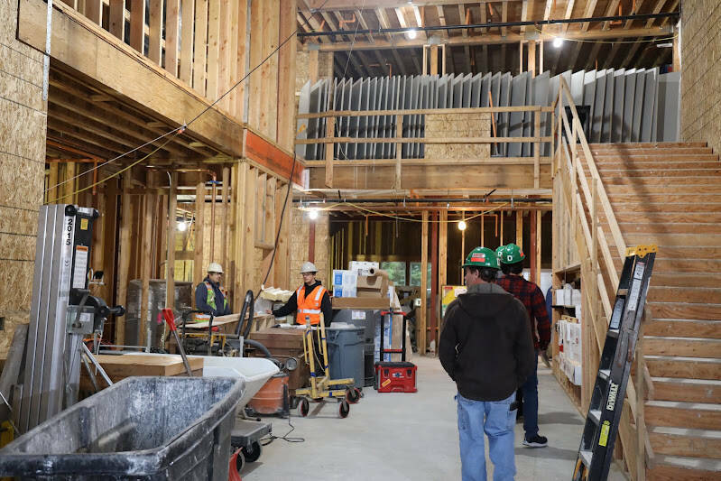 People stand at the entrance of the Riverview Senior Living facility in during construction in October. According to Brian Pierce, the project superintendent, occupancy is expected beginning in mid-February of 2023. (Clarise Larson / Juneau Empire)