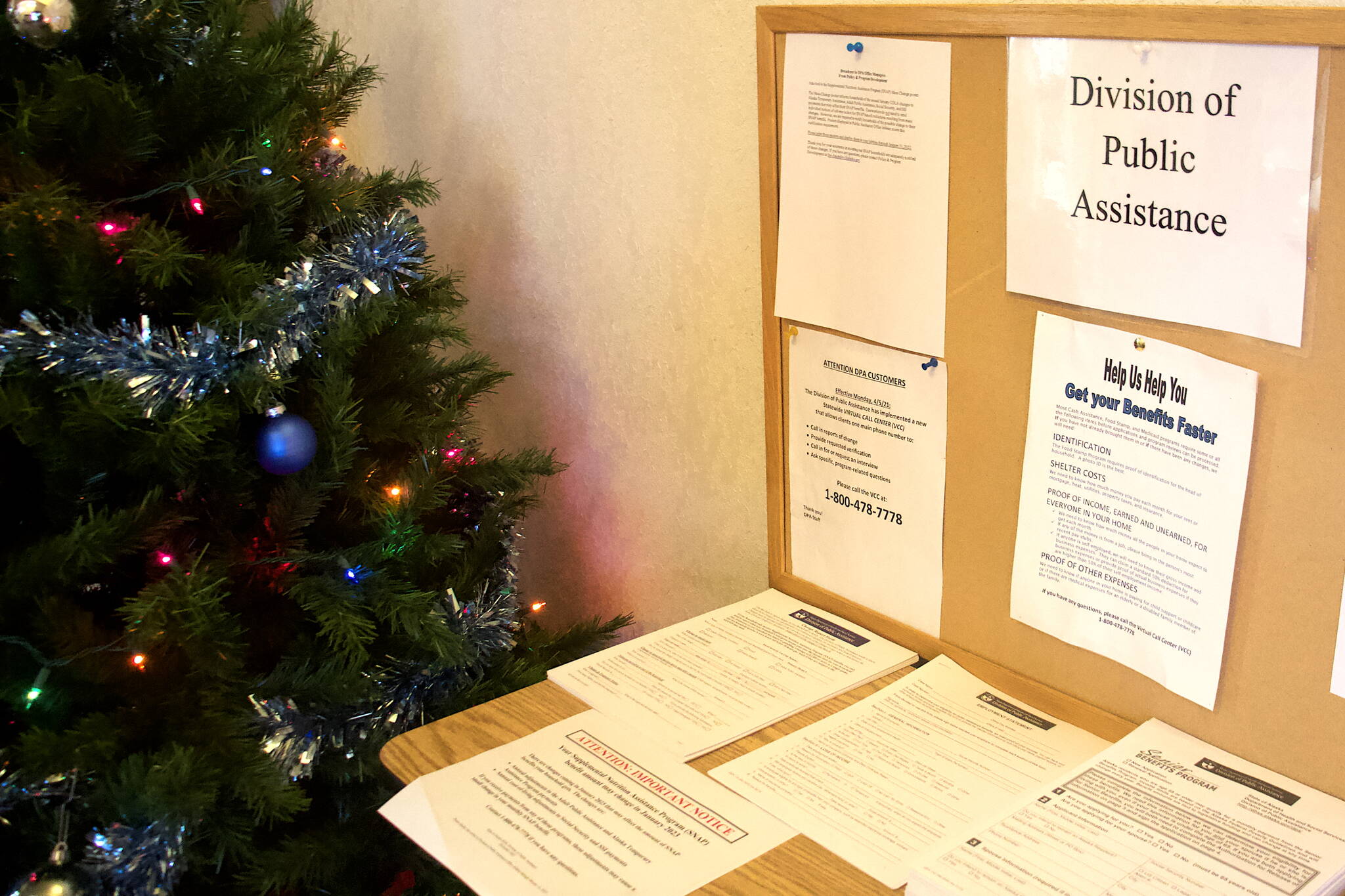 Applications and notifications about changes to benefits line a table at the entrance of the Alaska Division of Public Assistance office in Juneau. The division’s Supplemental Nutrition Assistance Program (SNAP) is months behind processing applications to due to workforce shortages and lingering problems of a cyberattack. (Mark Sabbatini / Juneau Empire)