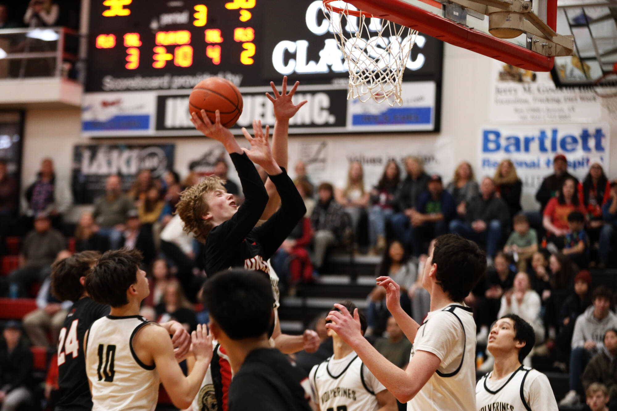 Junior guard Sean Oliver pushes through a crowd of players for a layup during the third period during Thursday night’s game against South Anchorage High School during the first night of the Princess Cruises Capital City Classic. (Clarise Larson / Juneau Empire)