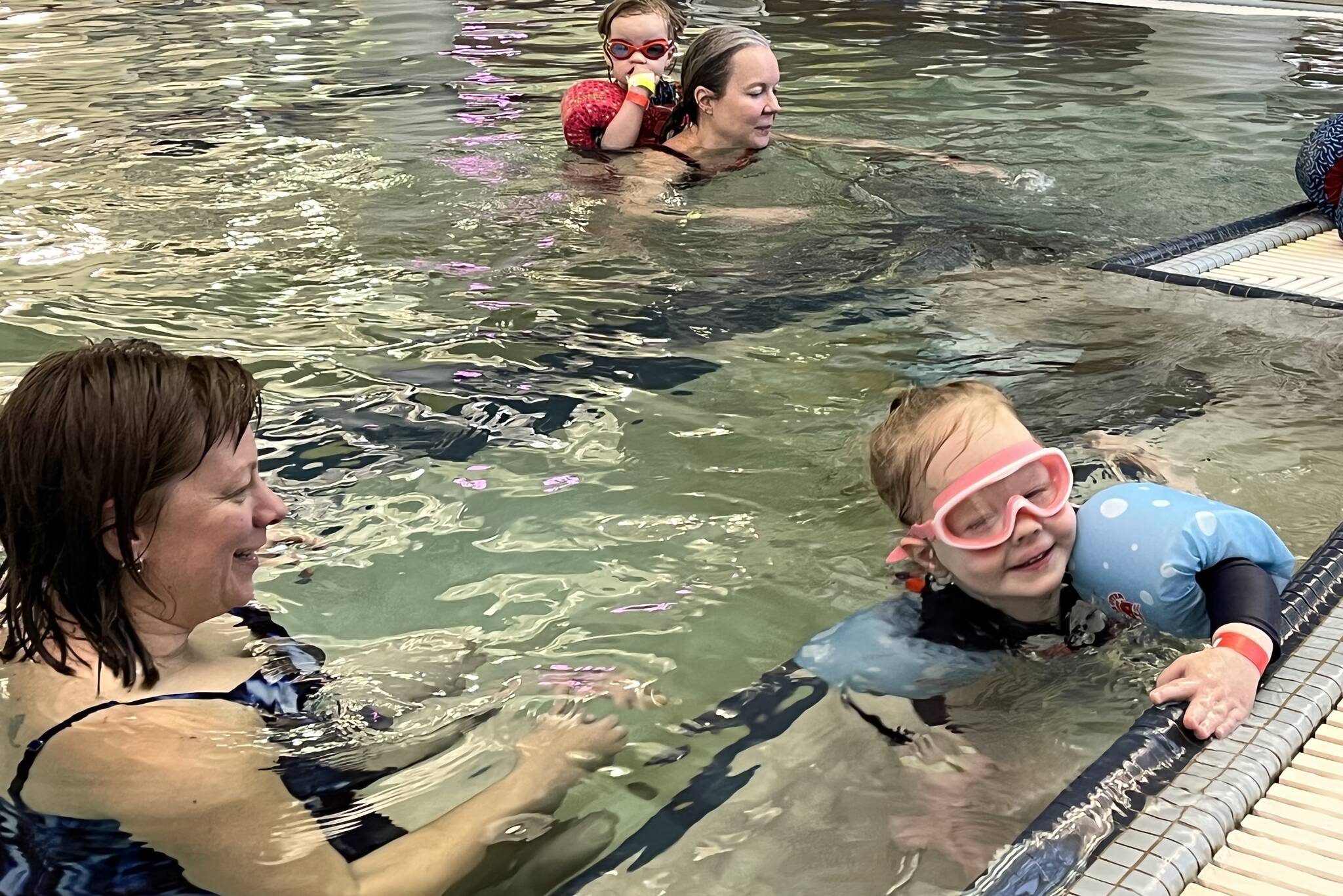 Christal Higdon and daughter Ophelia work on swimming in the deep end during Family Day at the Pool on Saturday at the Dimond Park Aquatic Center. (Jonson Kuhn / Juneau Empire)