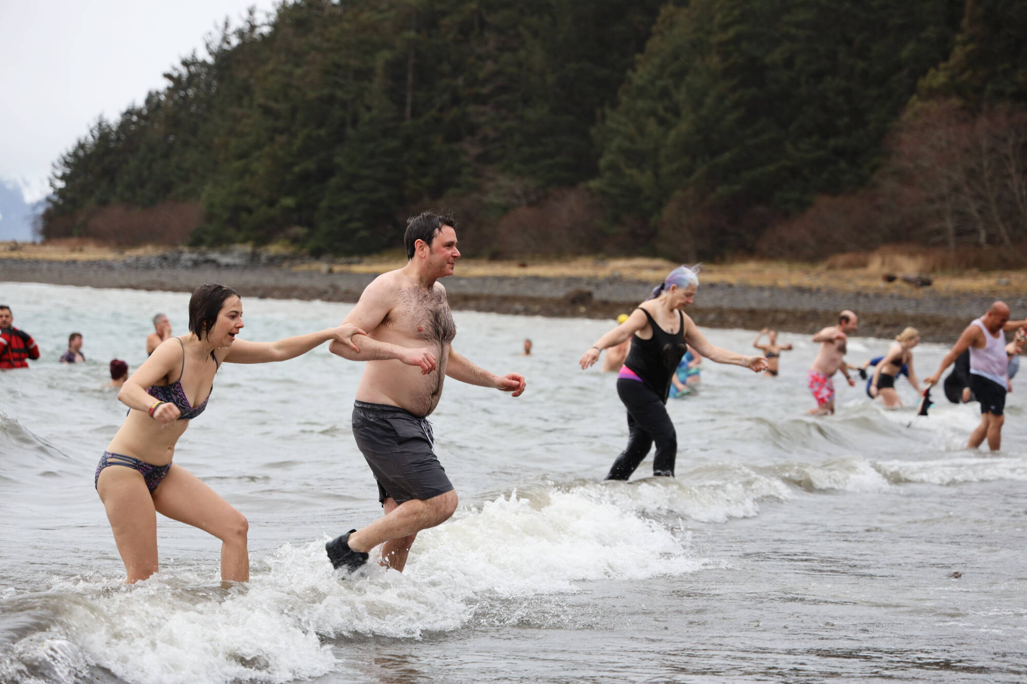 People run out of the cold ocean water on a cloudy Sunday afternoon for the annual Polar Dip at the Auke Recreation Area. (Clarise Larson / Juneau Empire)