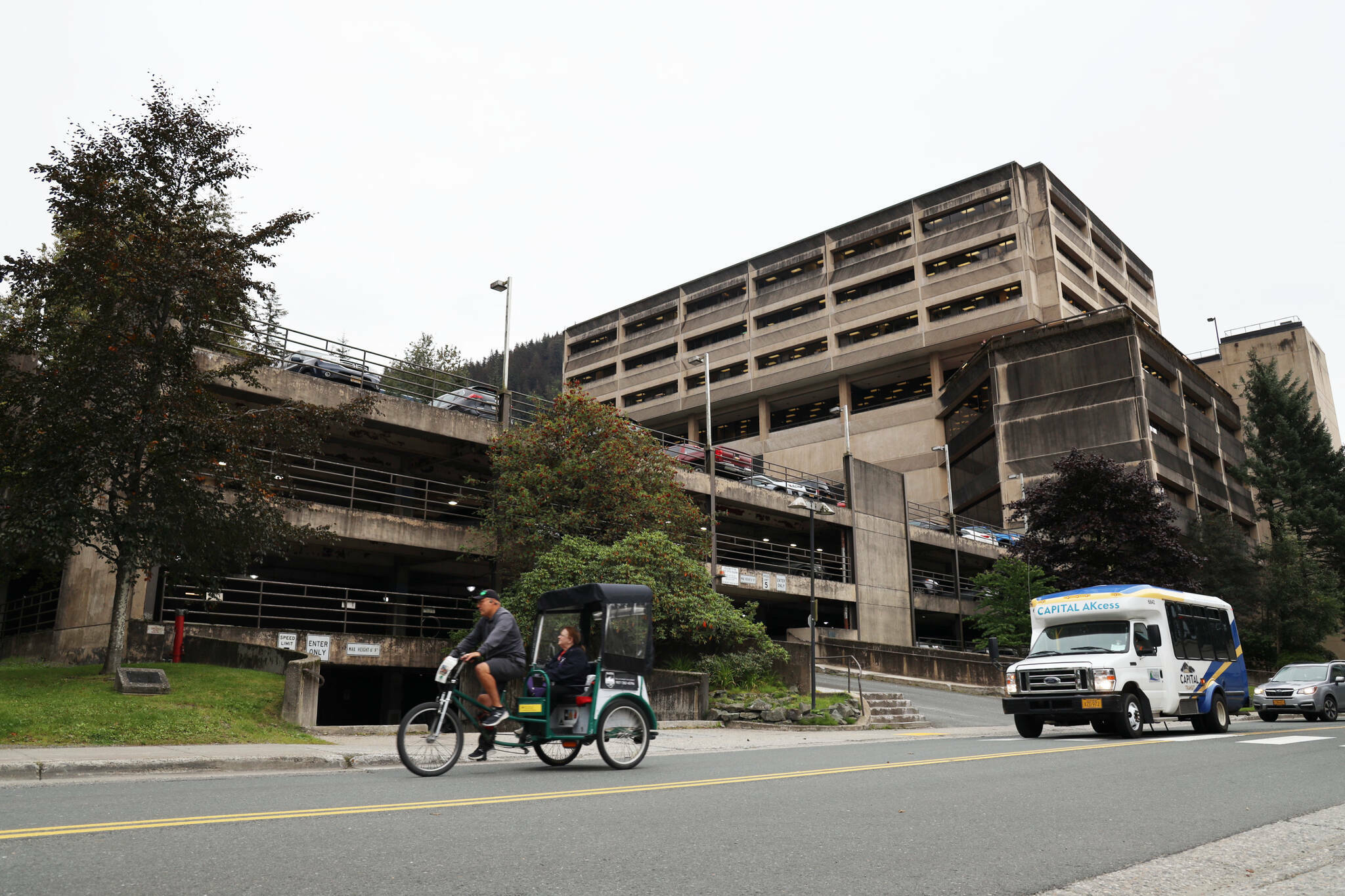 A cycle rickshaw passes the North State Office Building parking garage located on Willoughby Avenue in downtown Juneau in September. A $30 million request to pay for upgrades to the parking garage tied for first on a list of requests for state legislative funding as ranked by Juneau Assembly members. Assembly Member Alicia Hughes-Skandijs said expanding parking there can free up other downtown space for housing and other development, which is a top overall goal of city leaders. The parking upgrade is officially ranked second on the list since a request to further development of the Pederson Hill Subdivision had a higher ranking on last year’s priority list. (Clarise Larson / Juneau Empire)