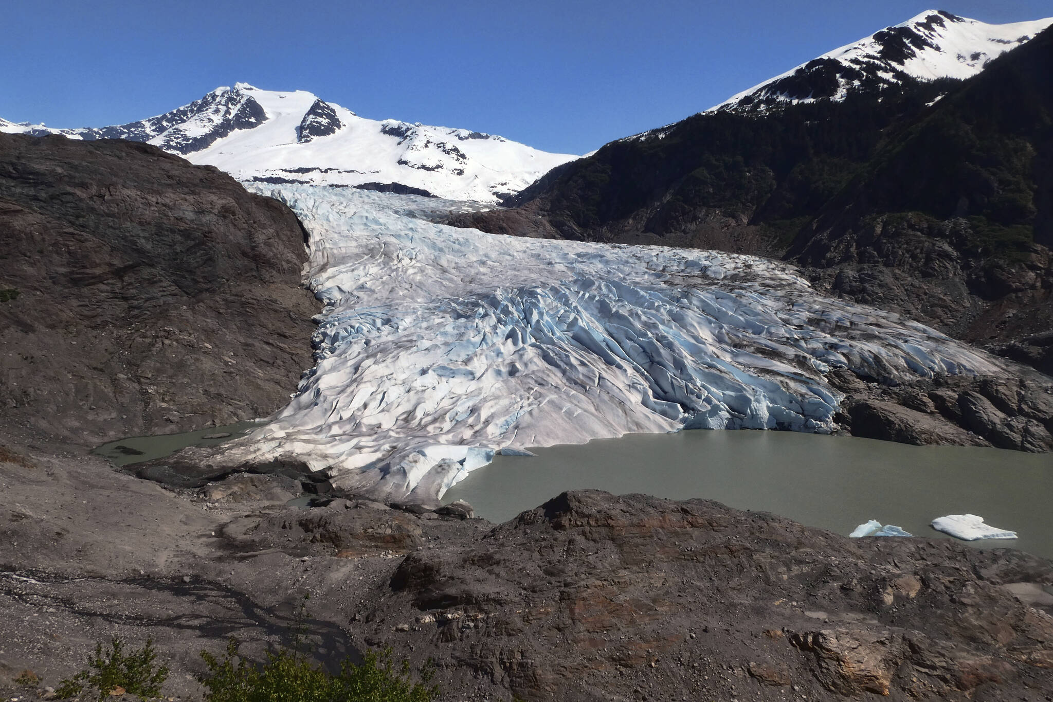 Chunks of ice float on Mendenhall Lake in front of the Mendenhall Glacier on Monday, May 30, 2022, in Juneau, Alaska. A study of all of the world's 215,000 glaciers published on Thursday, Jan. 5, 2023, finds even if with the unlikely minimum warming of only a few tenths of a degrees more, the world will lose nearly half its glaciers by the end of the century. With the warming we're now on track to get, the world will lose two-thirds of its glaciers and overall glacier mass will drop by one-third while sea level rises 4.5 inches just from melting glaciers. (AP Photo / Becky Bohrer)