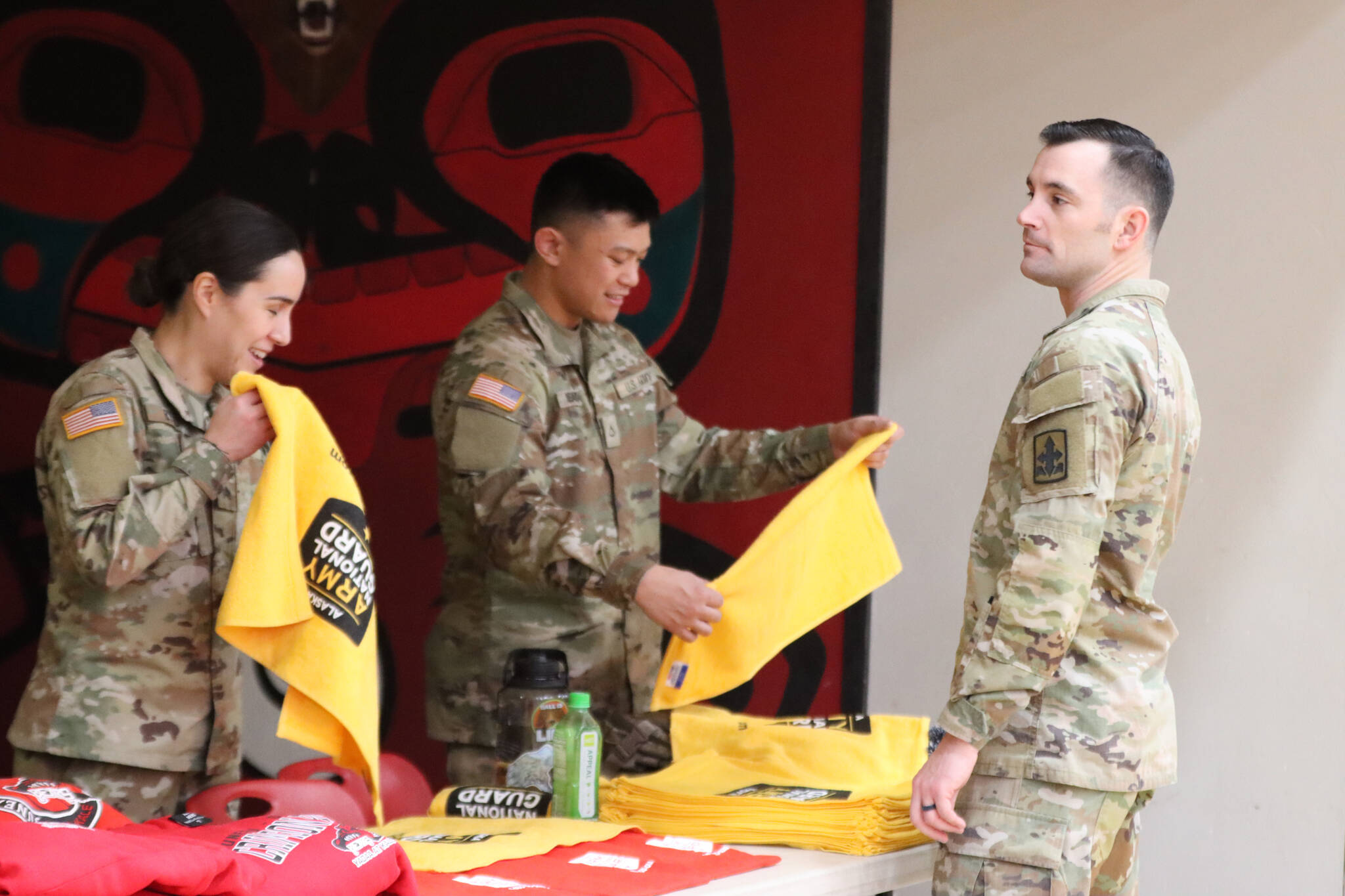 Members of the Alaska Army National Guard, Sgt. Heather Byrd, Staff Sgt. Sean Smack and Private First Class Kyrell De La Rosa hand out t-shirts and towels during Wednesday night’s Military Appreciation Night at JDHS. (Jonson Kuhn / Juneau Empire)