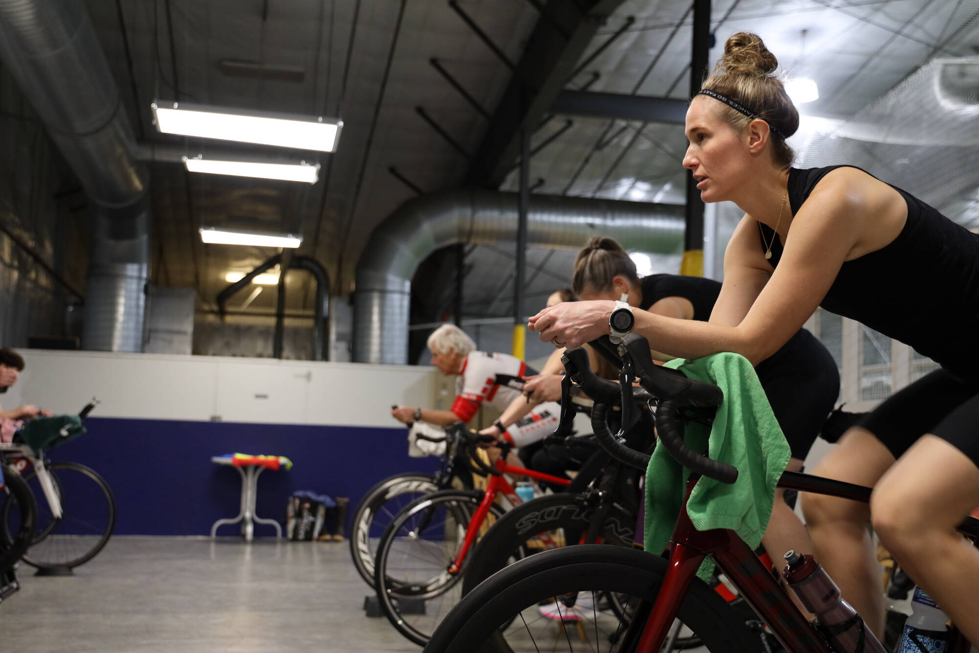 Clarise Larson / Juneau Empire
Jenna Weirsma pedals a stationary bike with other athletes during a High Cadence Triathlon Team workout at the Dimond Park Field House Thursday evening.
