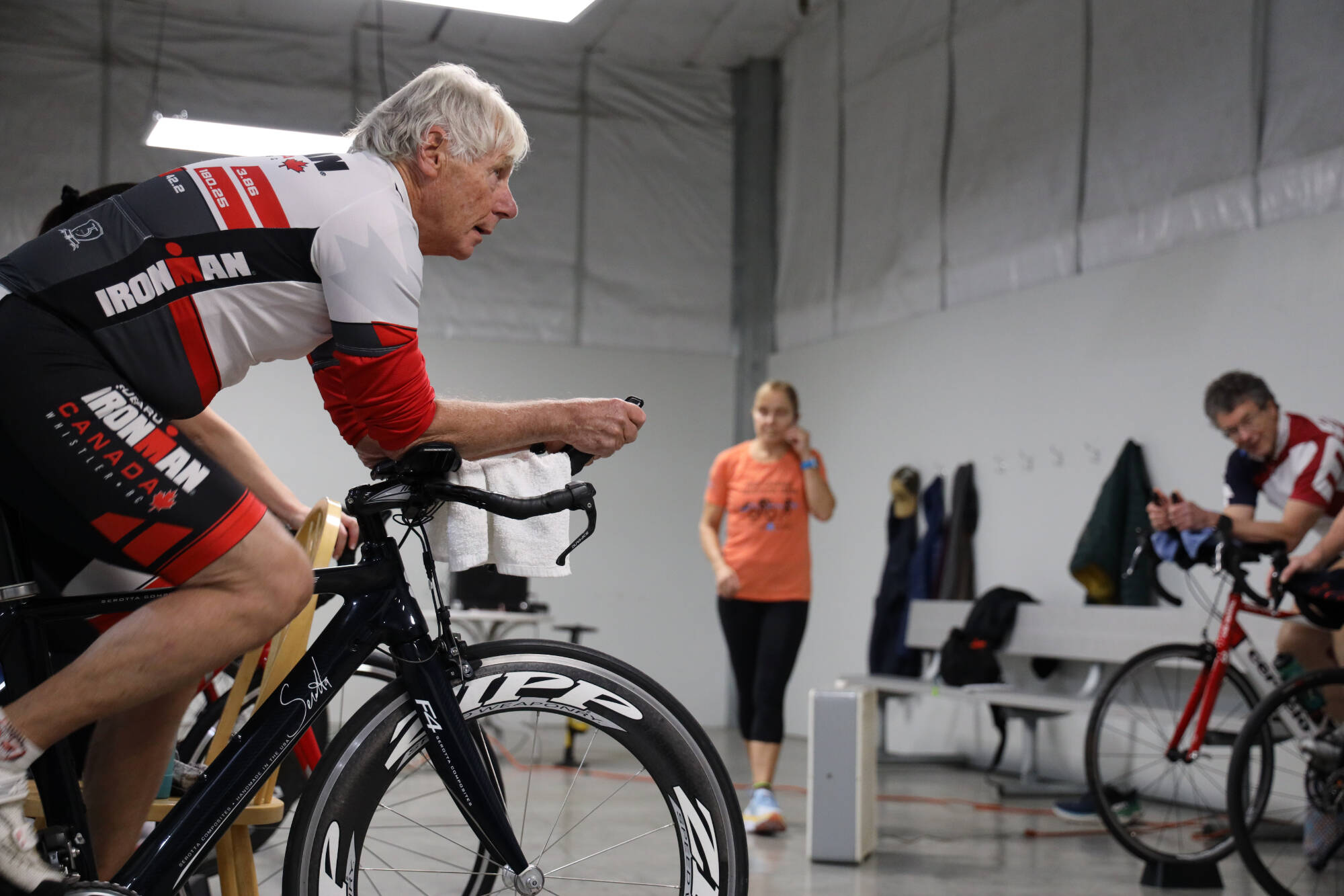 Reed Stoops pedals a stationary bike with other athletes during a High Cadence Triathlon Team workout at the Dimond Park Field House Thursday evening. Many athletes are still deciding what to do after it was announced in mid-December the Ironman Group announced its decision to cancel the Ironman Alaska races for 2023 and 2024.