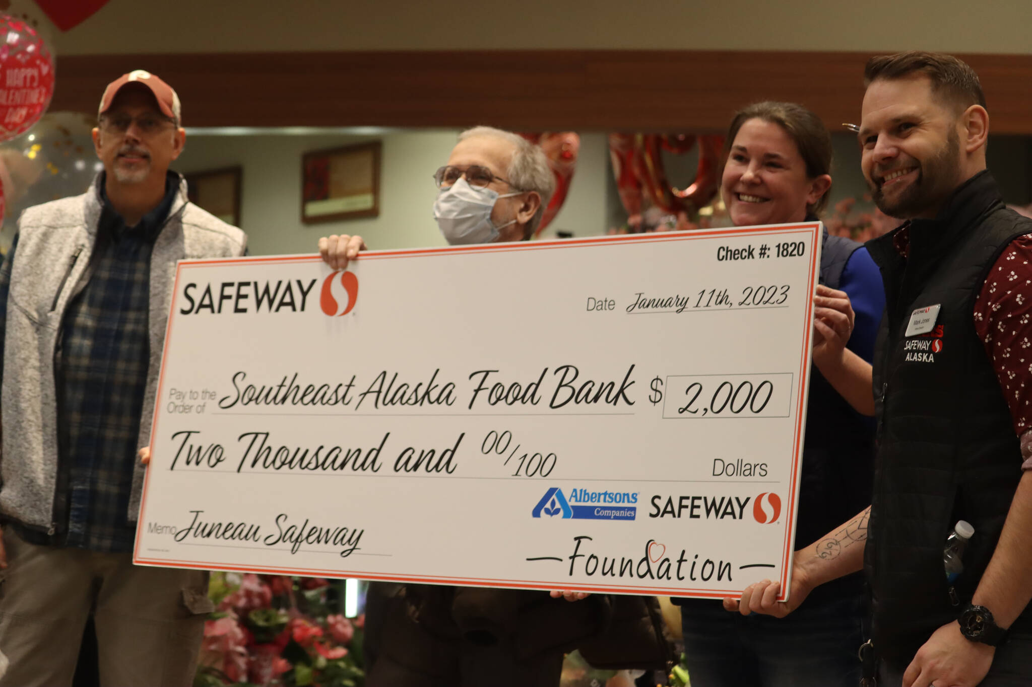 Safeway district manager Stephanie Kennedy and store director Mark Jones hand out a donation check to the Southeast Alaska Foodbank during a grand reopening ceremony on Wednesday. Foodbank manager Chris Schapp accepted the check on behalf of the foodbank. (Jonson Kuhn / Juneau Empire)