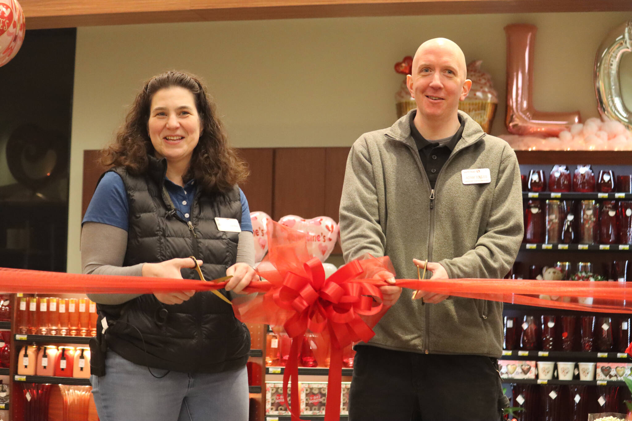 Safeway grocery manager Michelle Lecorchick and inventory control manager Adam Tolles cut the red ribbon during Wednesday’s grand reopening ceremony for the store’s Juneau location. (Jonson Kuhn / Juneau Empire)