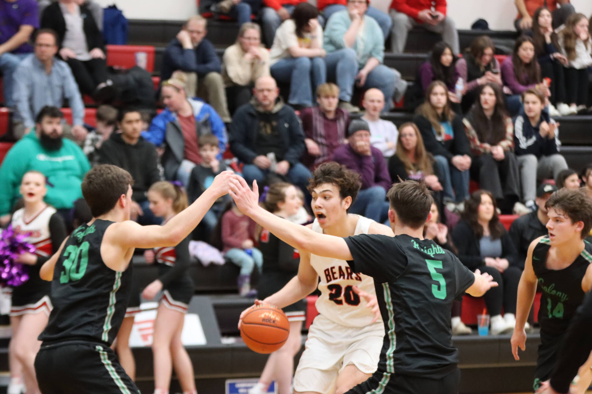 JDHS senior Orion Dybdahl takes the ball down court while being closely guarded by two defenders on Wednesday nights game. Dybdahl led the Crimson Bears in scoring with 19 points. (Jonson Kuhn / Juneau Empire)