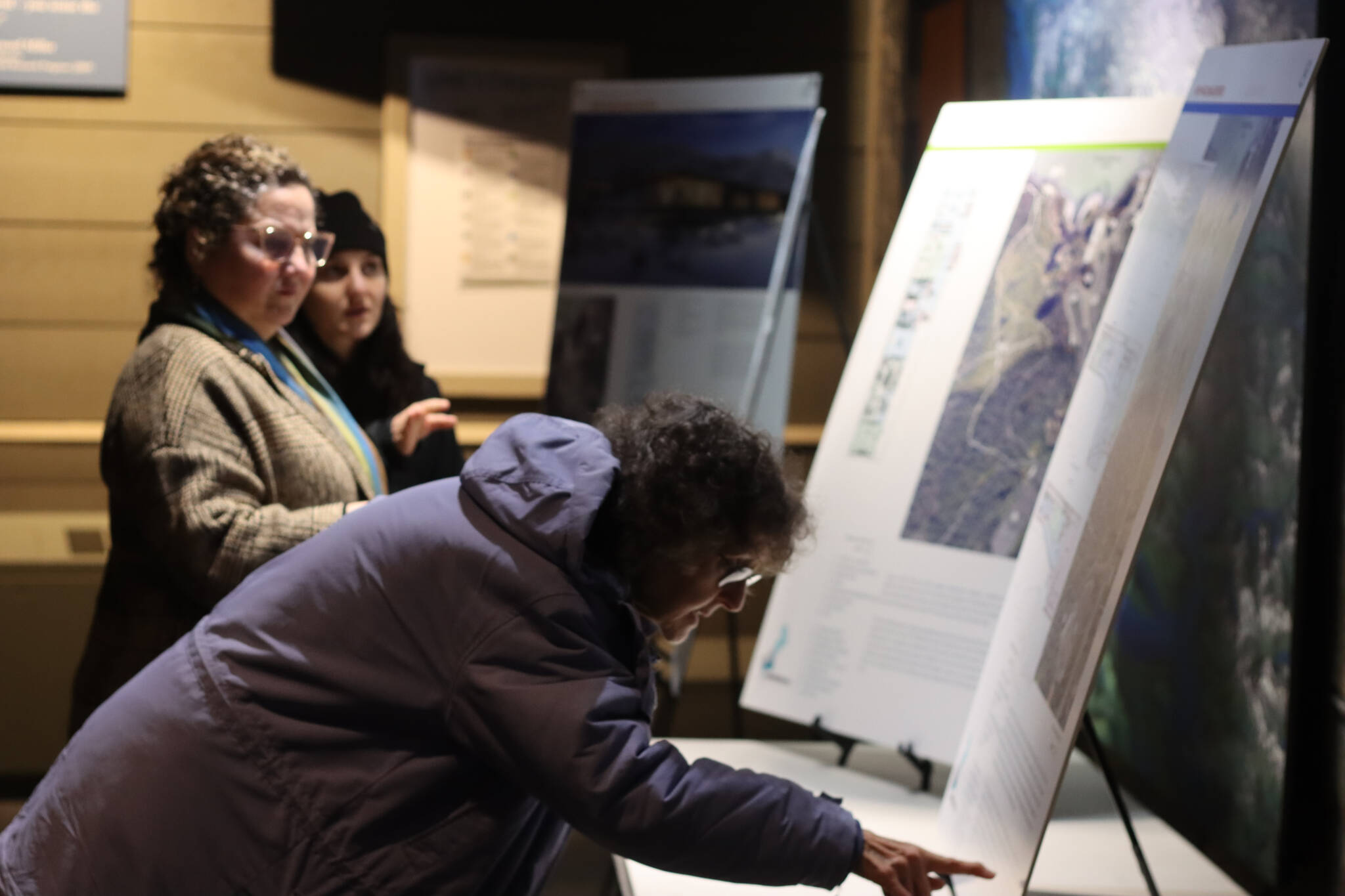Jonson Kuhn / Juneau Empire 
Juneau residents view informational boards set up throughout the Mendenhall Glacier Visitor’s Center on Tuesday during an open house to provide an overview of alternatives proposed for changes to the recreation area.
