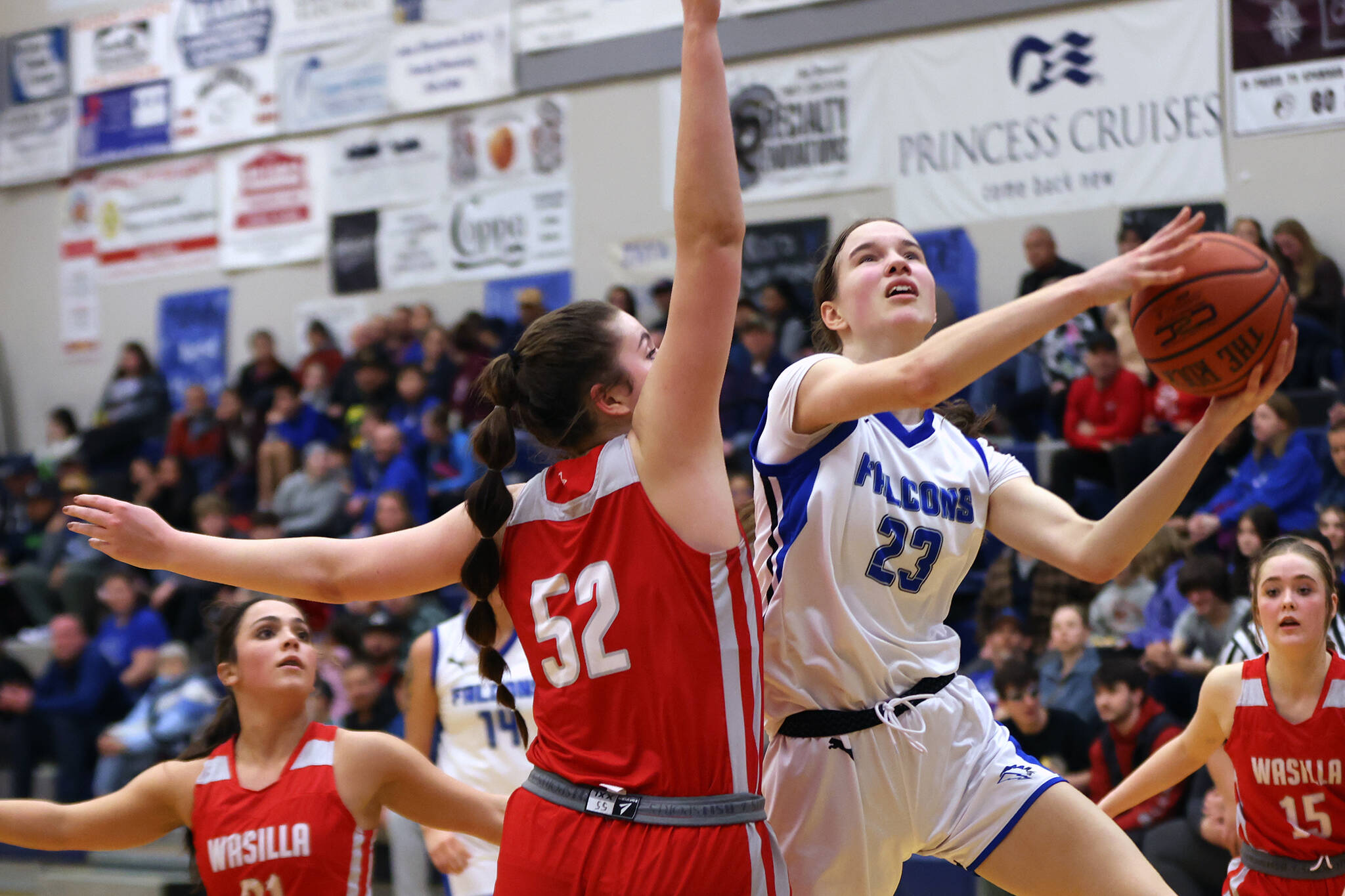 TMHS sophomore Cailynn Baxter (23) attempts to maneuver around the outstretched arm of Wasilla sophomore Layla Hays (52). (Ben Hohenstatt / Juneau Empire)