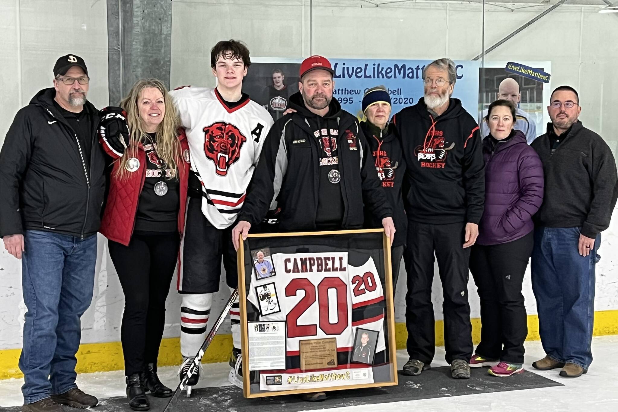 Photos by Jonson Kuhn/Juneau Empire The Campbell family, along with former JDHS hockey coach Jay Lloyd, display a framed jersey in honor of Matthew Campbell, whose number was retired during a special ceremony Saturday at Treadwell Arena.