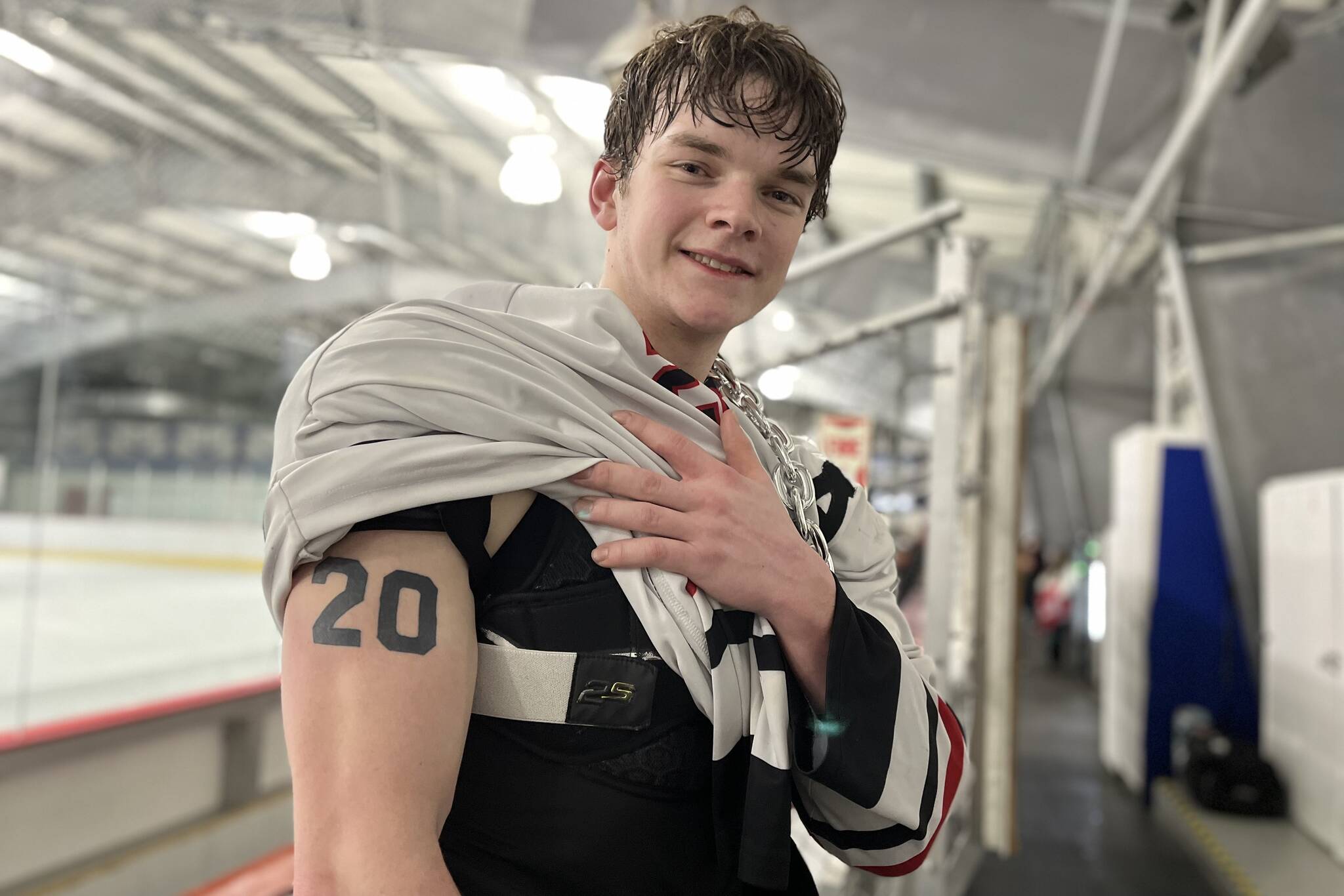 JDHS senior Brandon Campbell shows his tattoo that pays tribute to his late brother Matthew at Treadwell Arena after a victory game against Tri-Valley High School. The 20 on Brandon’s arm matches Matthew’s jersey number, which was retired in a special ceremony during Saturday’s game. (Jonson Kuhn / Juneau Empire)