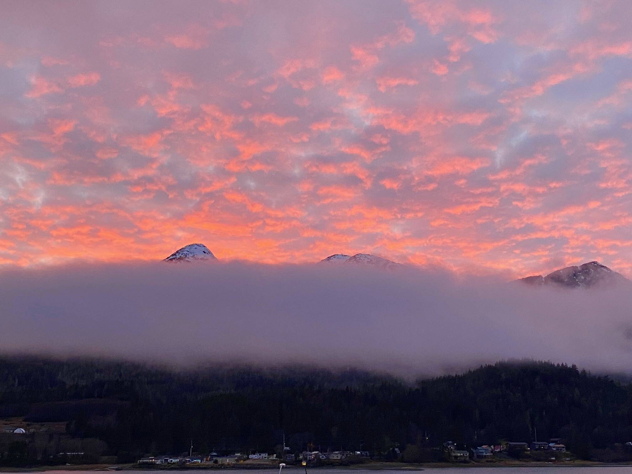 Low clouds rest on the Douglas range while high clouds reflect the setting sun. (Courtesy Photo / Denise Carroll)