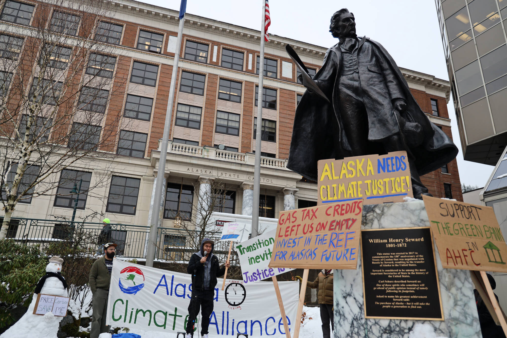 Climate activists hold a rally outside the Alaska State Capitol Friday afternoon in advocacy for legislative action to improve Alaska’s renewable energy development and future sustainability. (Clarise Larson / Juneau Empire)