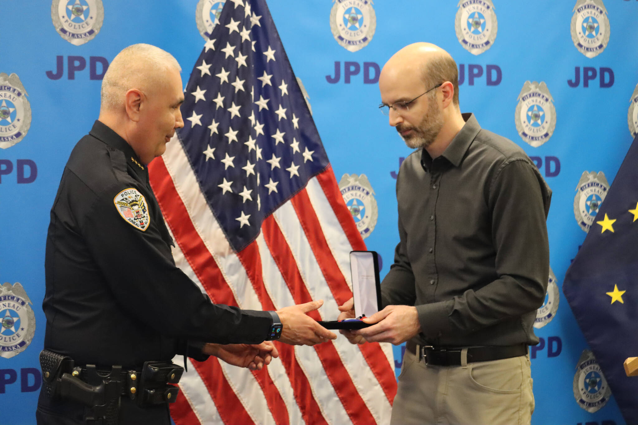 CBJ Deputy City Manager Robert Barr presents a Lifesaving Medal to JPD Chief Ed Mercer on Monday during the JPD’s annual award ceremony. Mercer was awarded for his assistance in rescuing passengers from the boat after running aground on Favorite Reef. (Jonson Kuhn / Juneau Empire)