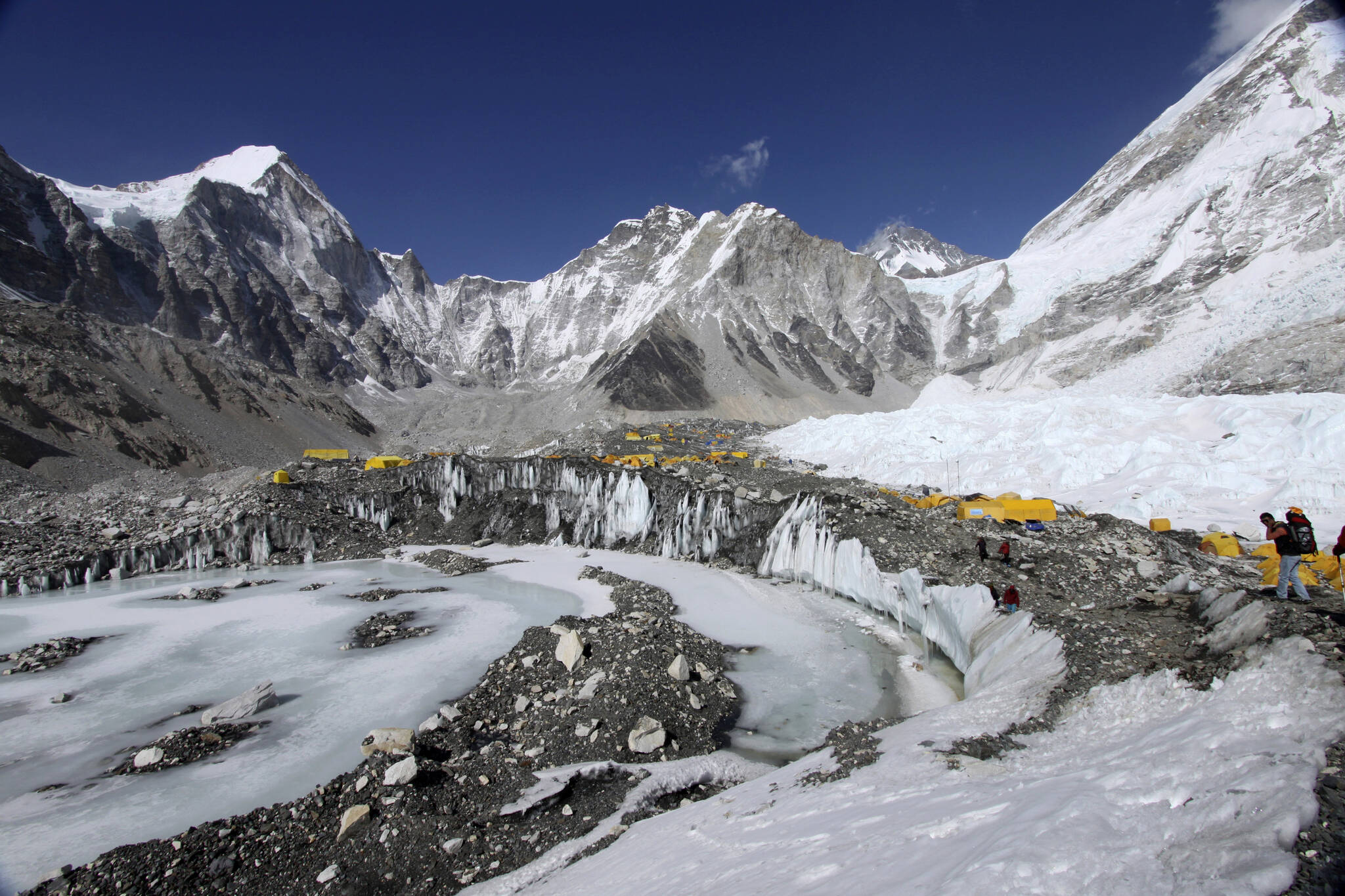 Tents are set up for climbers on the Khumbu Glacier, with Mount Khumbutse, center, and Khumbu Icefall, right, seen in background, at Everest Base Camp in Nepal on April 11, 2015. As glaciers melt and pour massive amounts of water into nearby lakes, 15 million people across the globe live under the threat of a sudden and deadly outburst flood, a new study finds. (AP Photo/Tashi Sherpa)