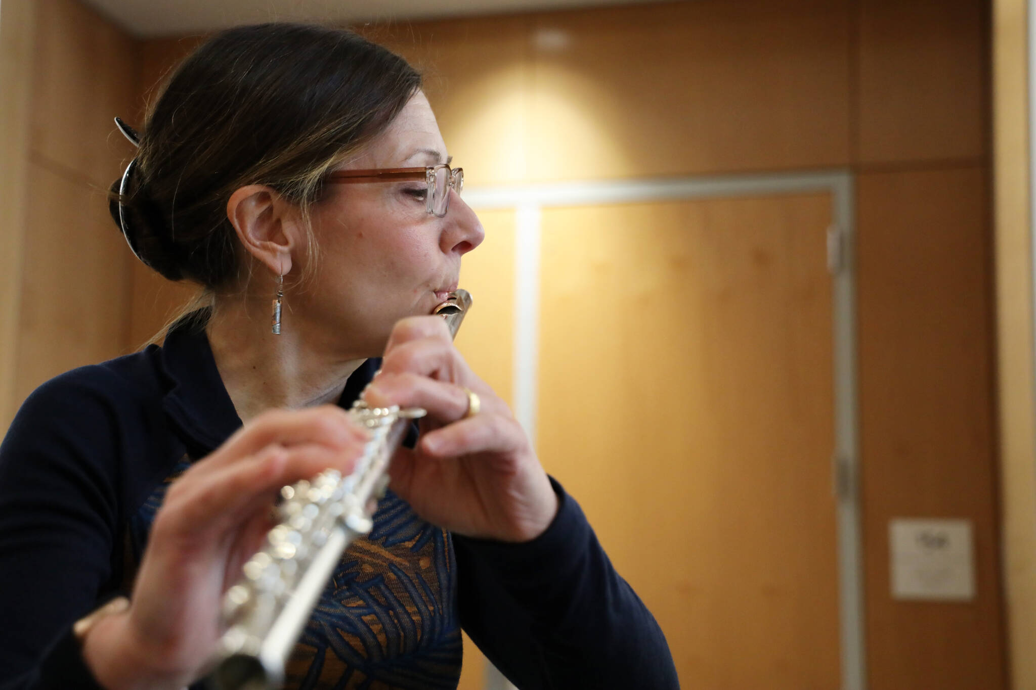 Sally Schlichting practices the flute at the Alaska State Library, Archives and Museum Atrium Monday afternoon in preparation for her upcoming solo concert Saturday afternoon. (Clarise Larson / Juneau Empire)