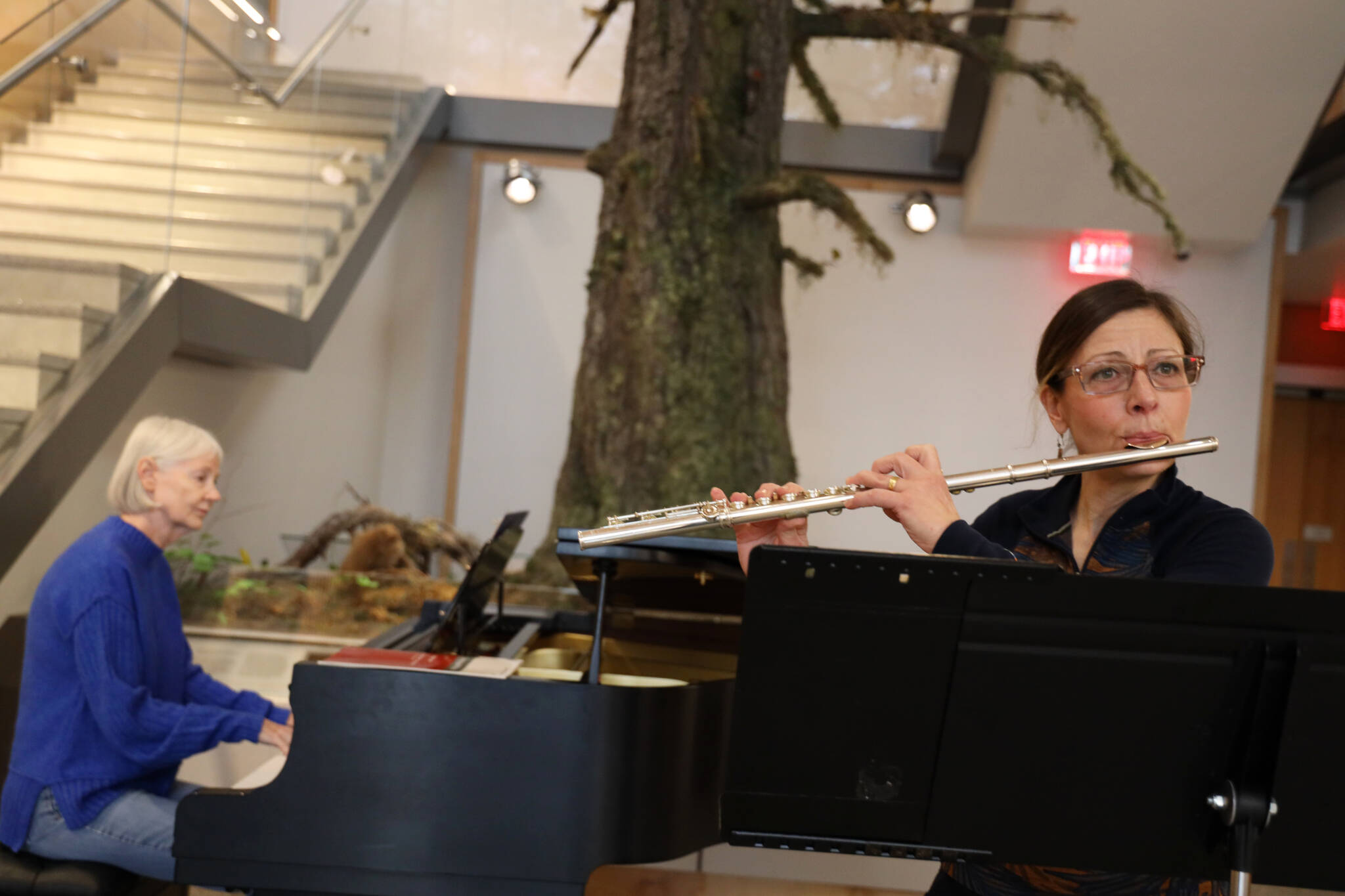 Sally Schlichting, on flute, and Sue Kazama, on piano, practice at the Alaska State Library, Archives and Museum Atrium Monday afternoon in preparation for Schlichting’s upcoming solo concert Saturday afternoon. (Clarise Larson / Juneau Empire)