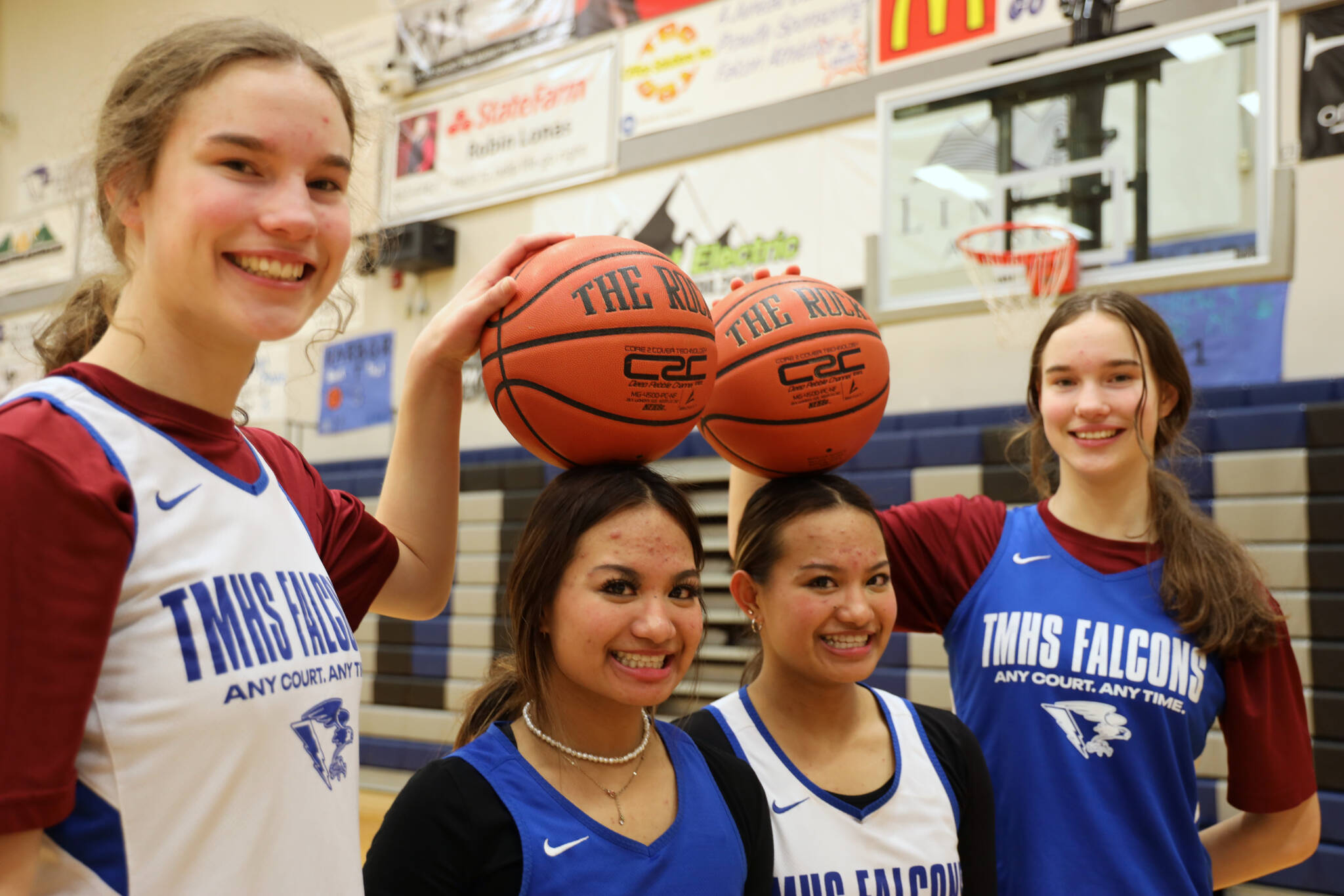 Sophomore twins Cailynn and Kerra Baxter, outside, and juniors twins Jaya and Mikah Carandang, inside, smile for a picture after their Monday night practice at Thunder Mountain High School. ( Clarise Larson / Juneau Empire)