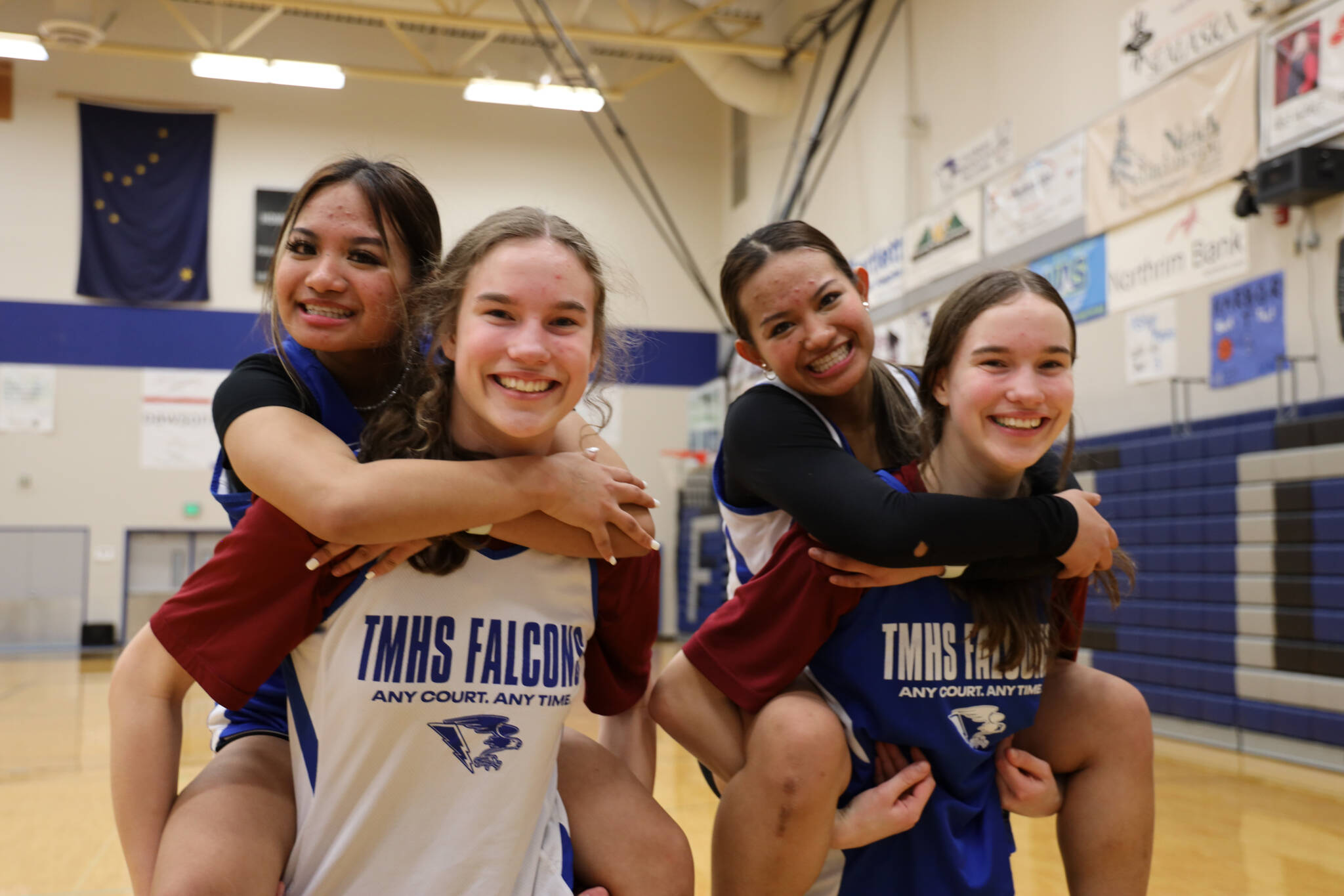 Sophomore twins Cailynn and Kerra Baxter, outside, and juniors twins Jaya and Mikah Carandang, inside, smile for a picture after their Monday night practice at Thunder Mountain High School. ( Clarise Larson / Juneau Empire)