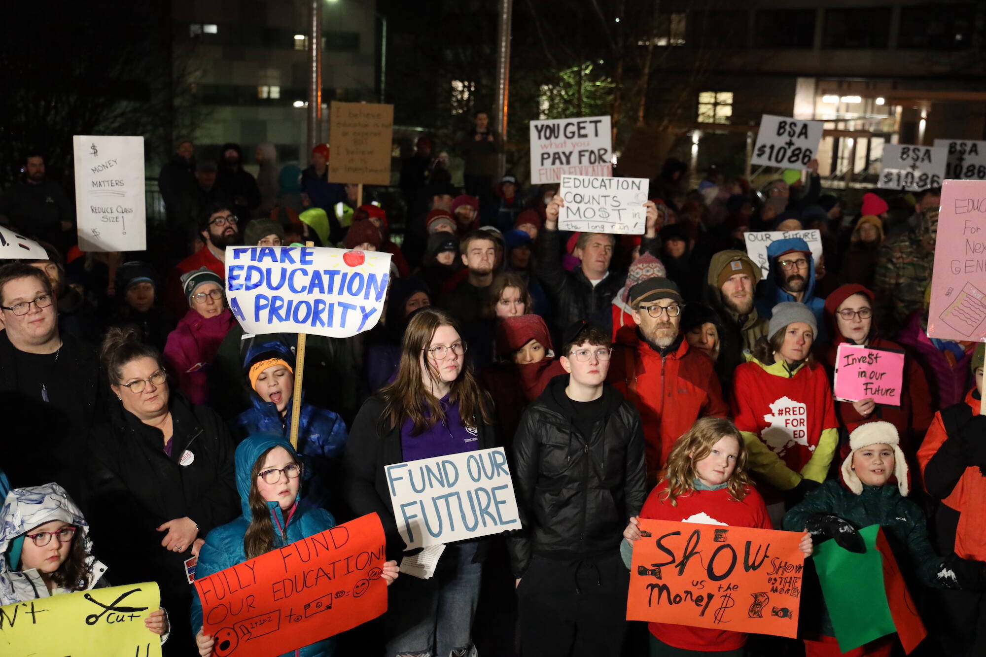 Dozens of Juneau teachers, students and residents gather at the steps of the Alaska State Capitol Monday evening in advocacy for an increase in the state’s flat funding via the base student allocation. (Clarise Larson / Juneau Empire)