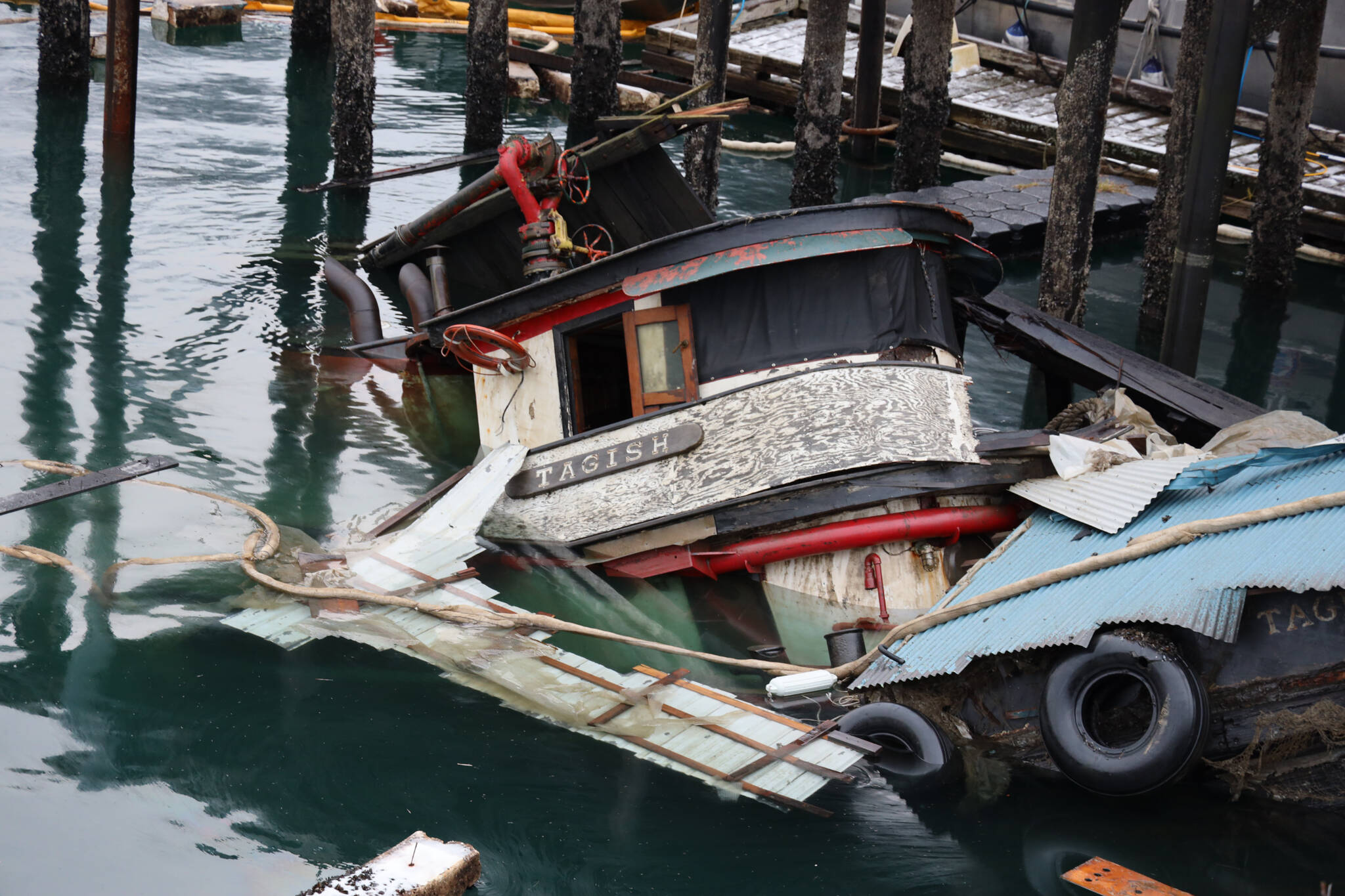 The privately owned 107-foot tugboat, the Tagish, sits partially below the water south of the downtown cruise ship docks Thursday morning as recovery efforts begin by the Coast Guard. (Clarise Larson / Juneau Empire)