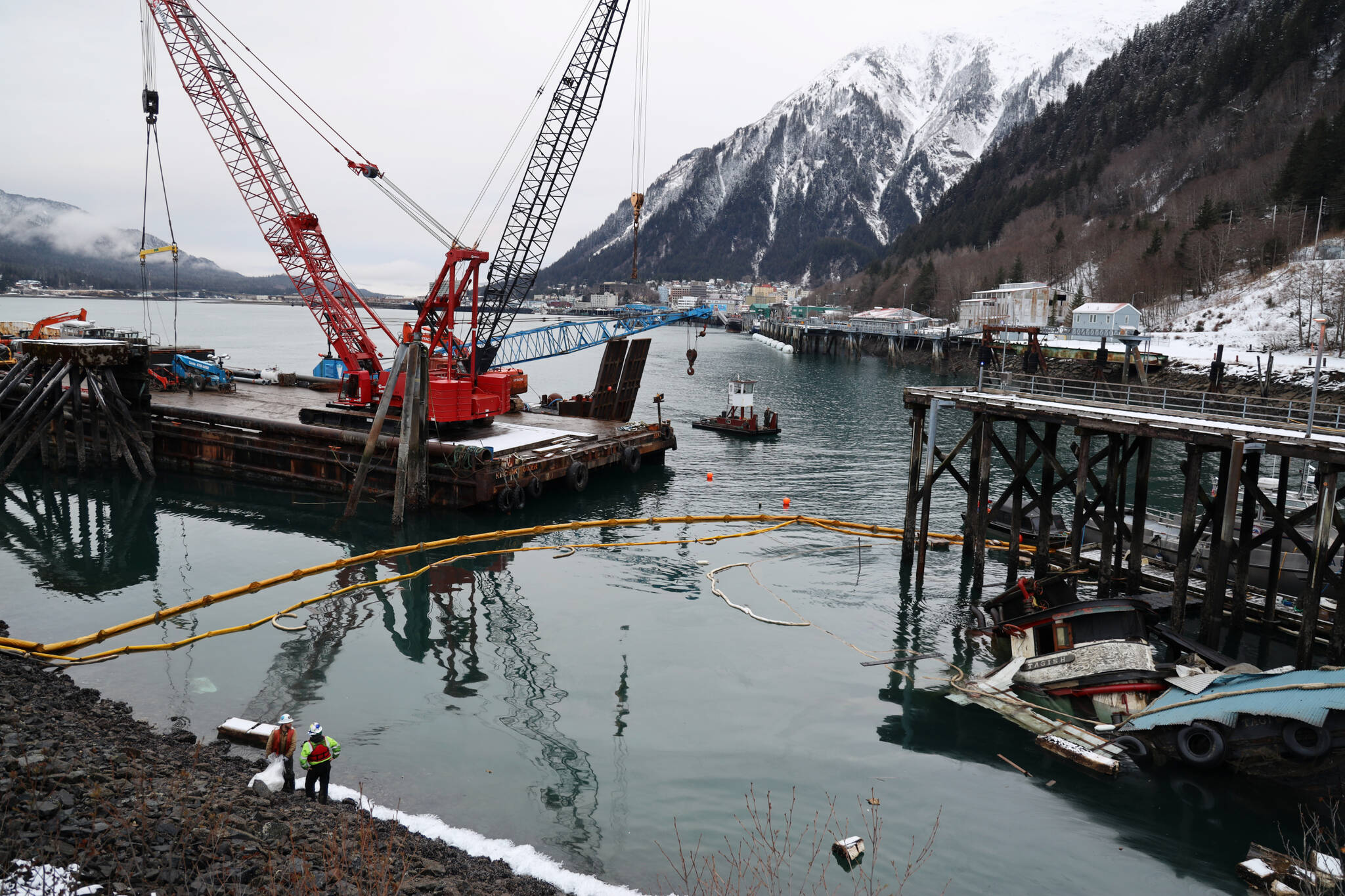 The privately owned 107-foot tugboat named Tagish sits partially below the water south of the downtown cruise ship docks Thursday morning as recovery efforts begin by the Coast Guard. (Clarise Larson / Juneau Empire)