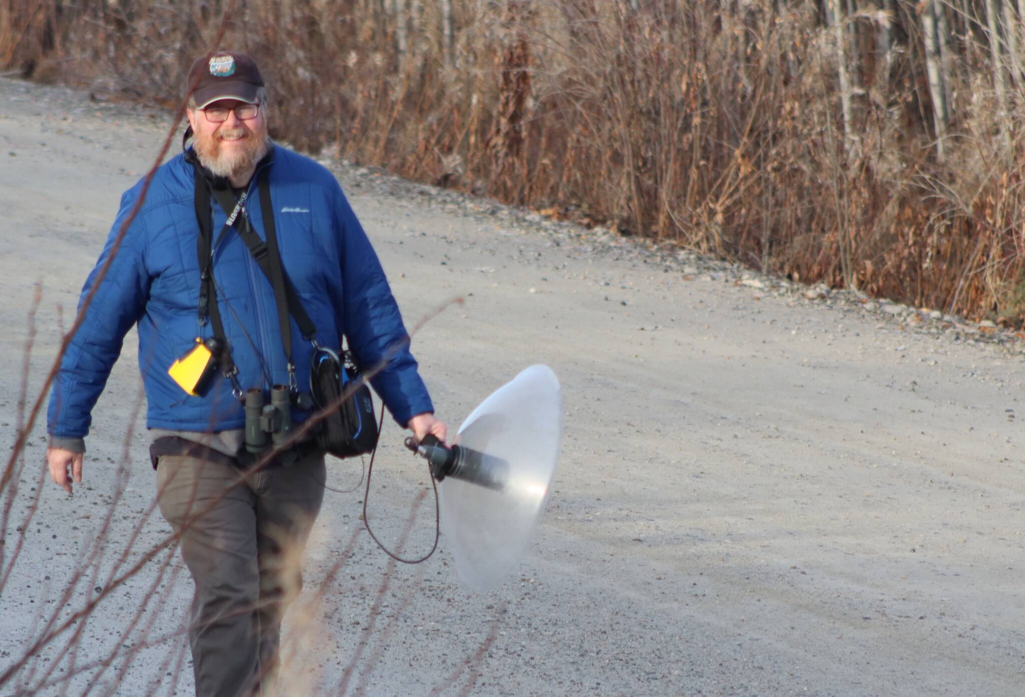 Doug Wacker walks a Fairbanks road last fall while pursuing ravens, the voices of which he is recording.(Courtesy Photo / Kim Wacker)