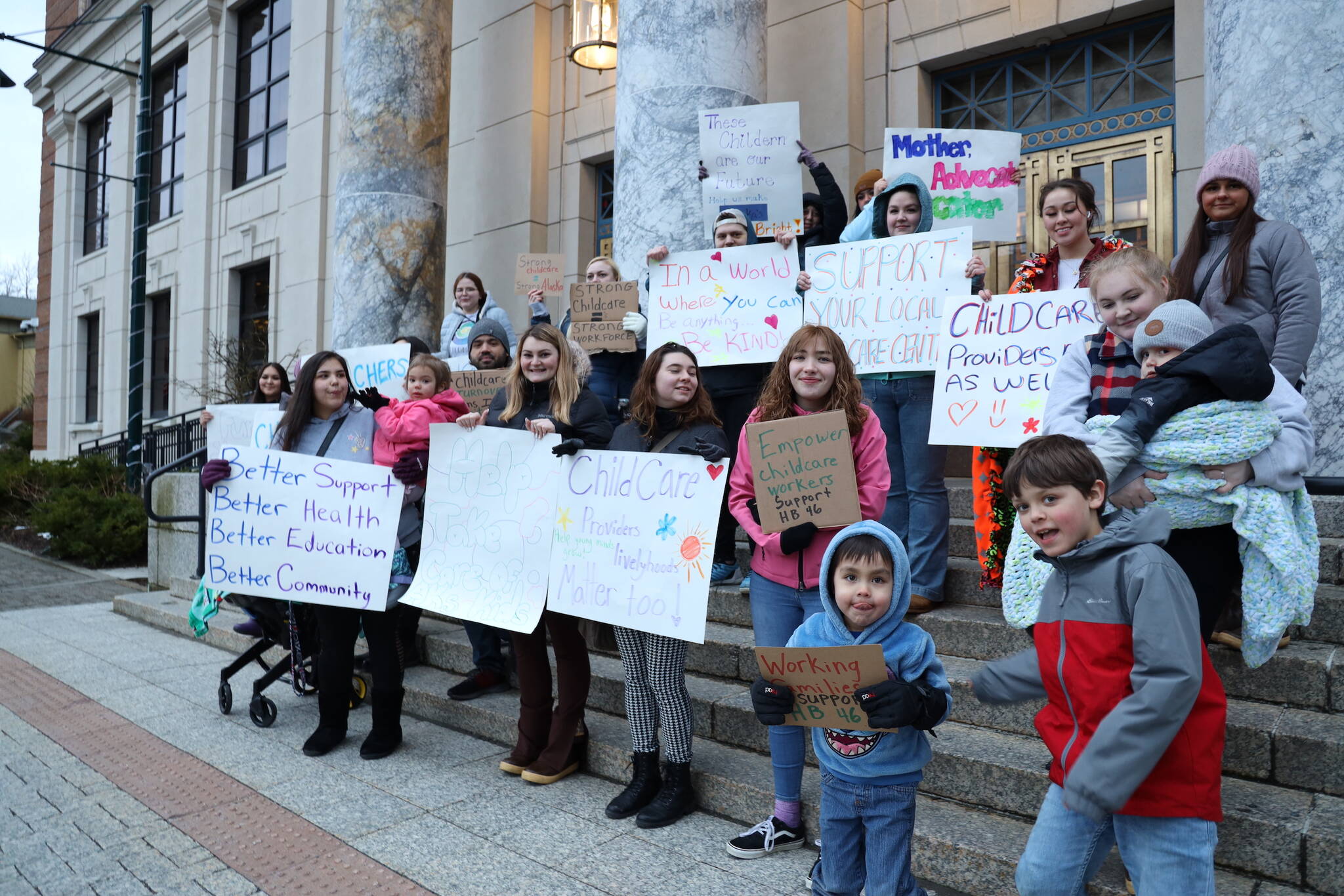 Supporters of a bill that would allow child care providers to participate in collective bargaining with the state’s Department of Health and establish a state fund to provide grants to childcare providers stand outside the Alaska State Capitol early Friday evening. (Clarise Larson / Juneau Empire)