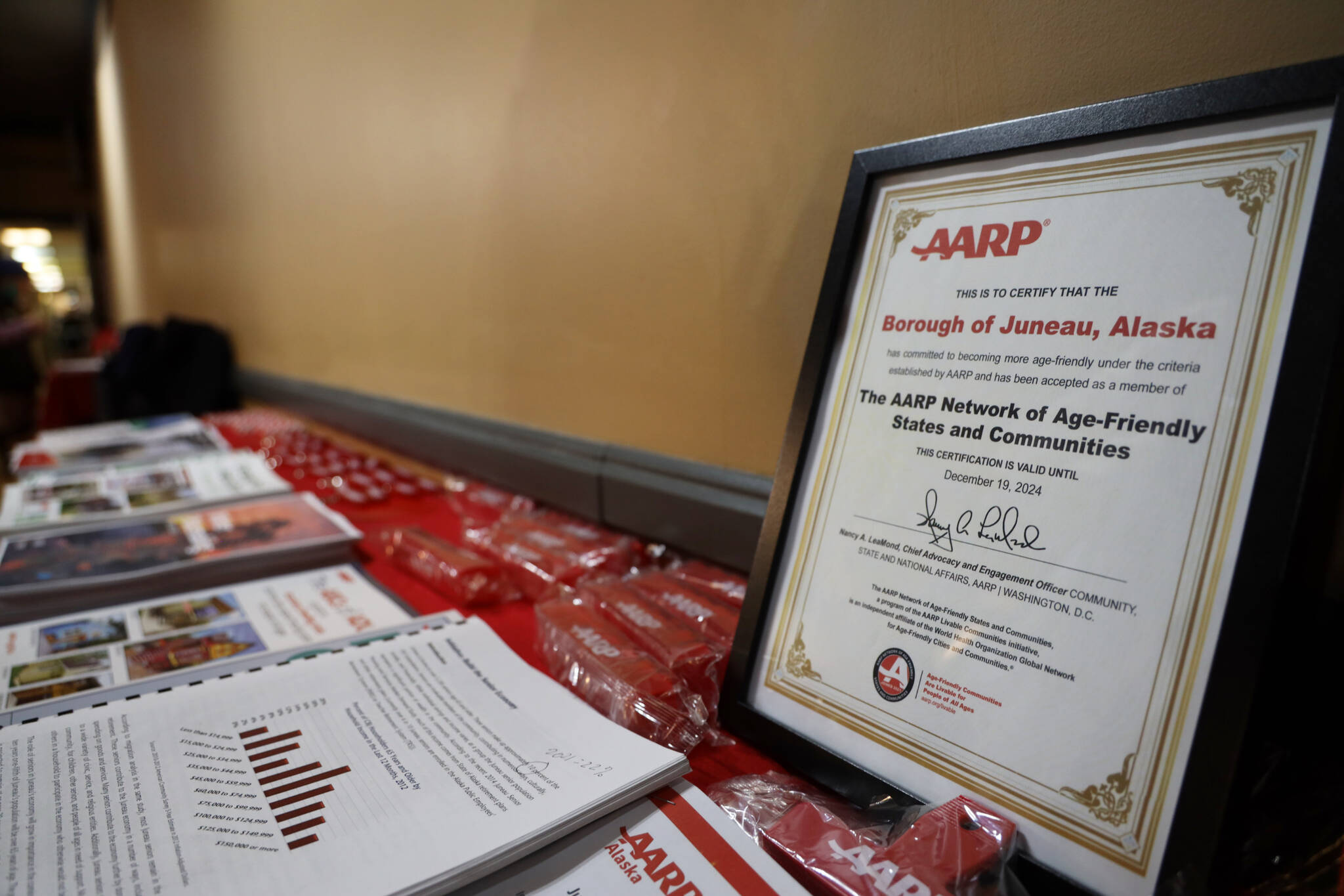 A table of resources and complimentary items was set up at the AARP Alaska’s Valentine’s Day-themed event Tuesday evening to celebrate Juneau’s older adult population along with the city’s recent commitment to ​​AARP’s Network of Age-Friendly States and Communities. (Clarise Larson / Juneau Empire)
