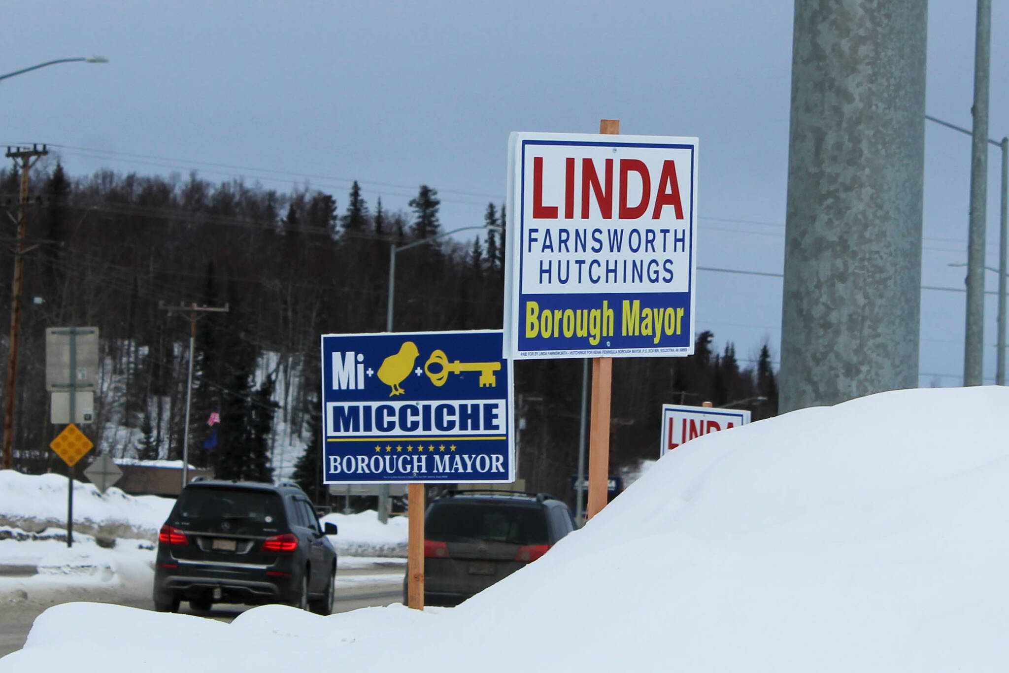 Signs supporting Kenai Peninsula Borough mayoral candidates Peter Micciche and Linda Farnsworth-Hutchings are staked in the snow at the intersection of the Kenai Spur and Sterling highways on Tuesday, Feb. 14, 2023, in Soldotna, Alaska. (Ashlyn O’Hara/Peninsula Clarion)